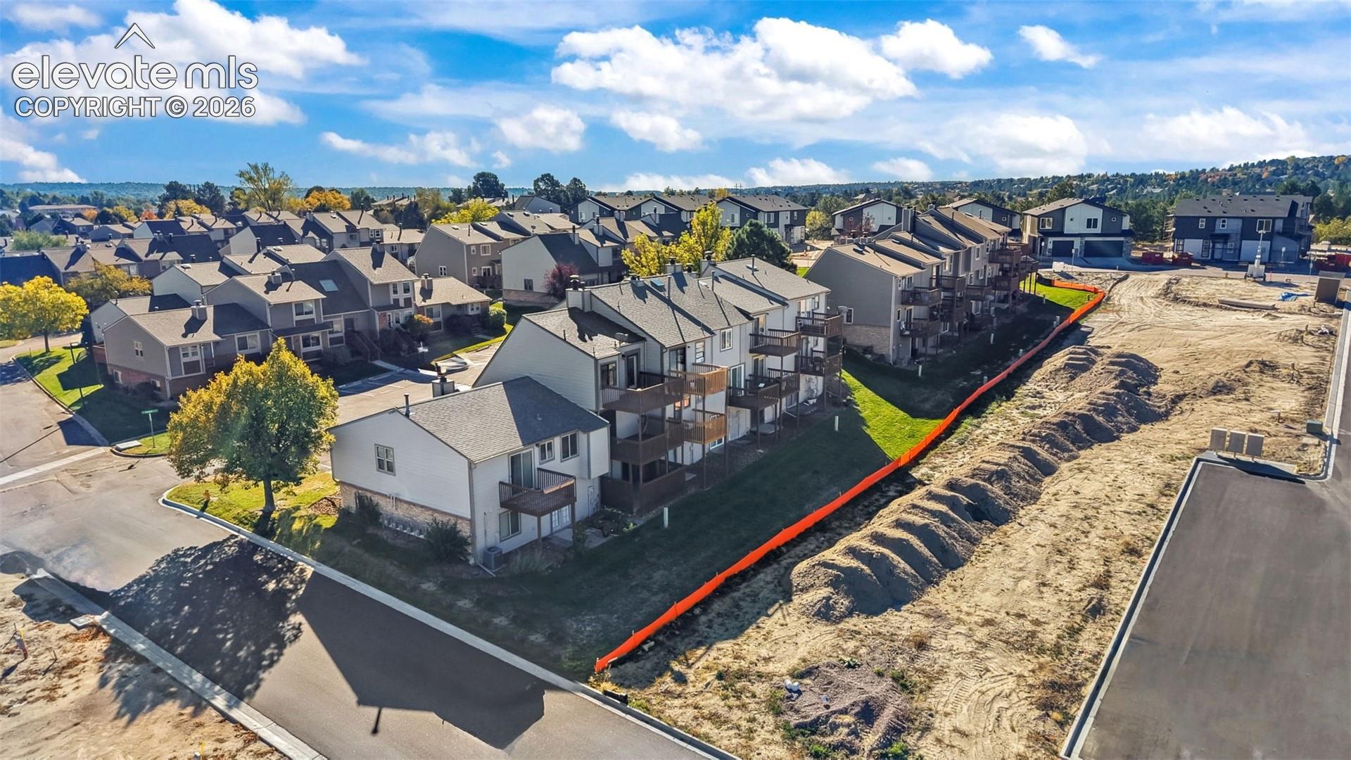 Aerial view of multi-level residential structures featuring vinyl siding, asphalt shingle roofing, and private elevated wooden balconies