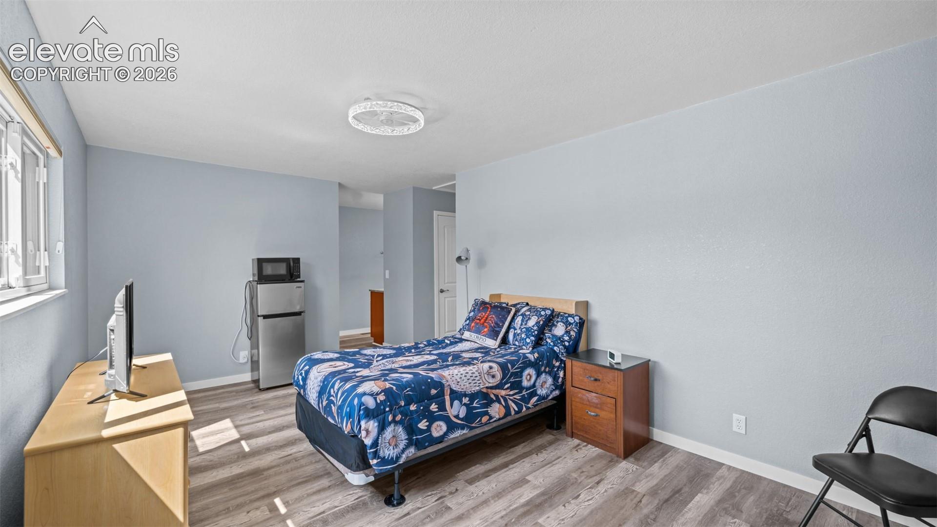 Light blue walls complement wood-finish flooring throughout this living space