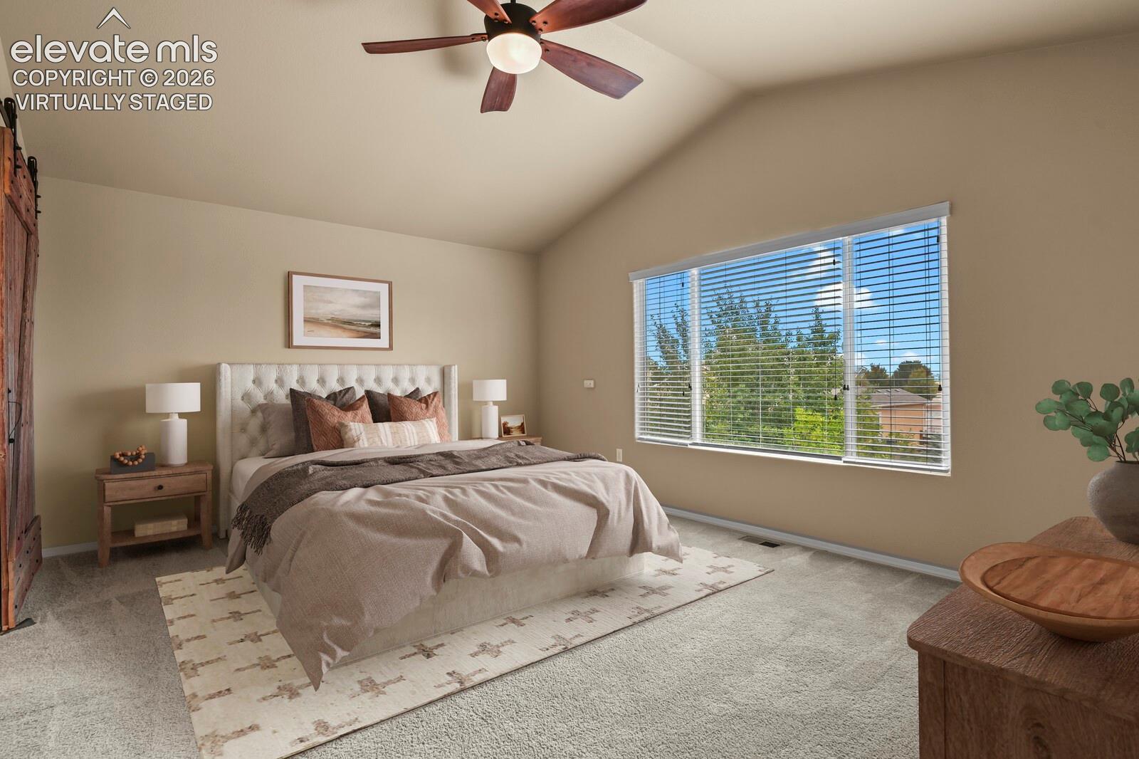 **Virtually Staged** Vaulted ceiling with a ceiling fan, broad window with blinds, and carpet flooring