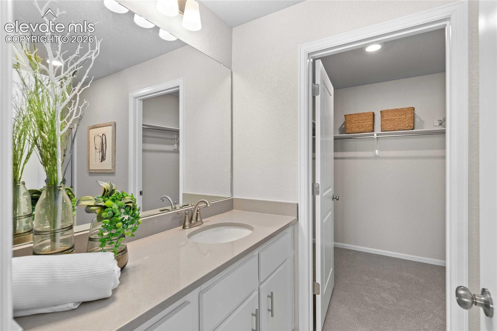 Single vanity with an undermount sink, brushed nickel faucet, large mirror, and overhead light fixture
*photos of a model home*