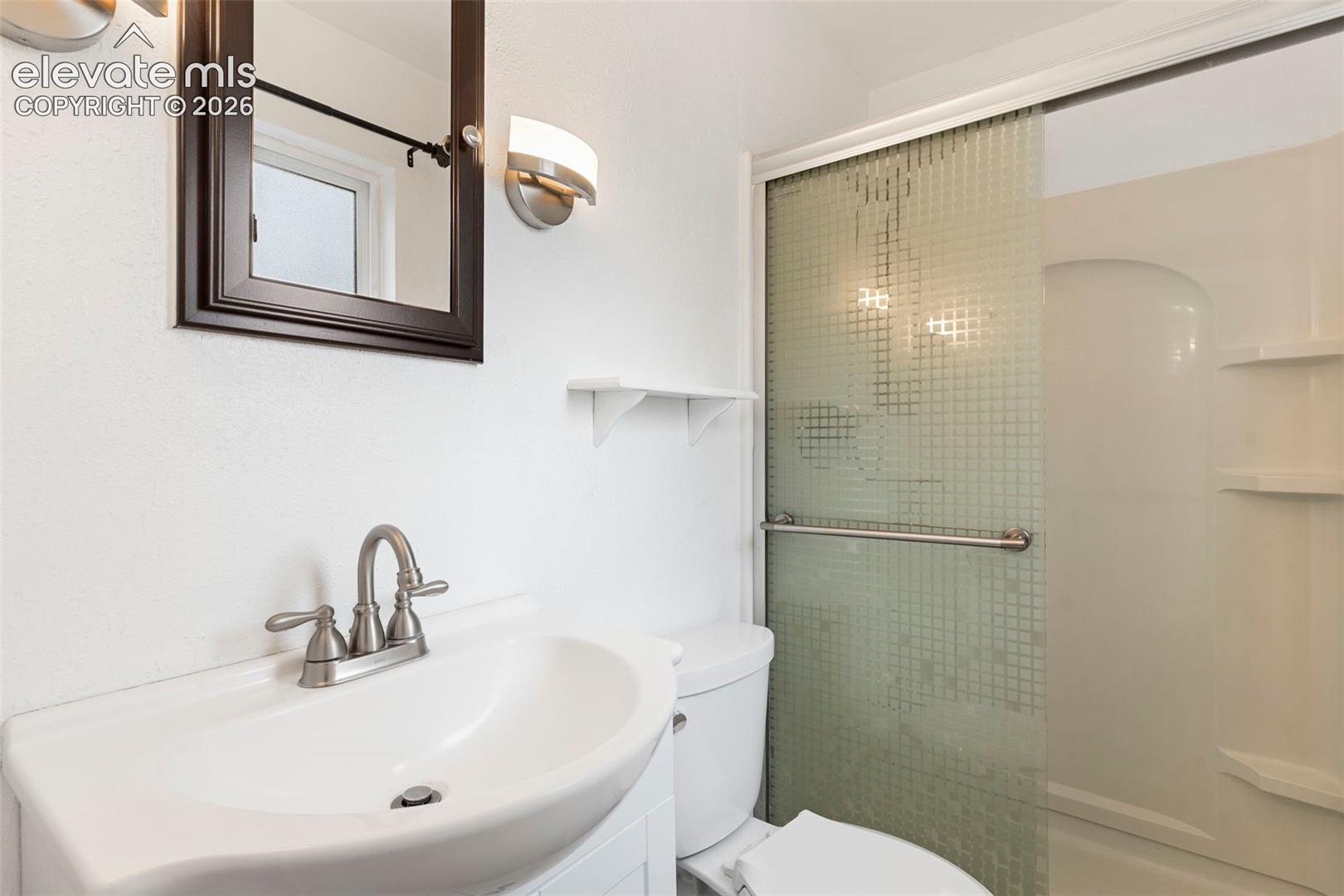 Wall-mounted vanity with a single basin sink and brushed nickel faucet