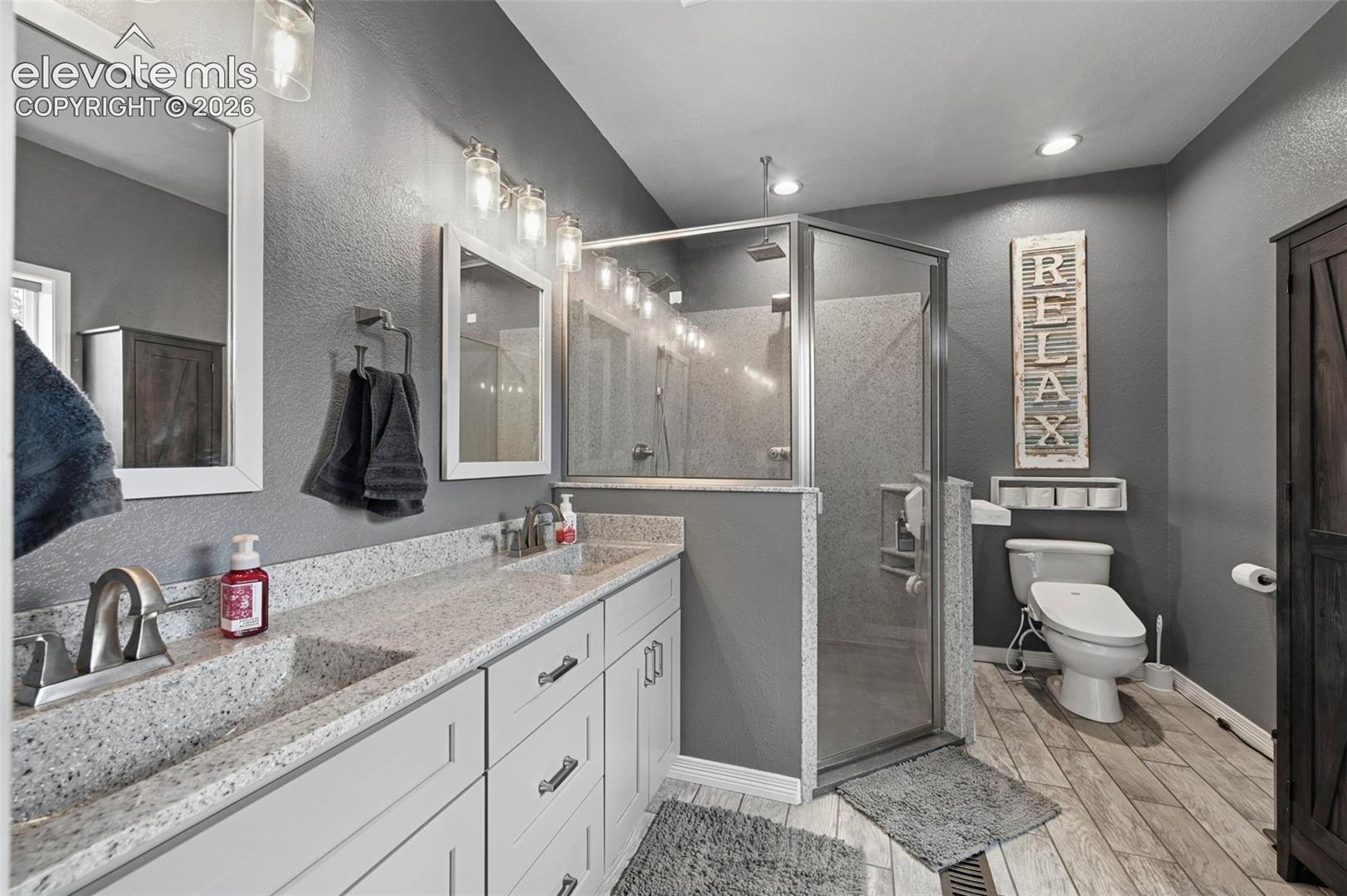 Dual vanity with undermount sinks, stone-finish countertops, and chrome fixtures