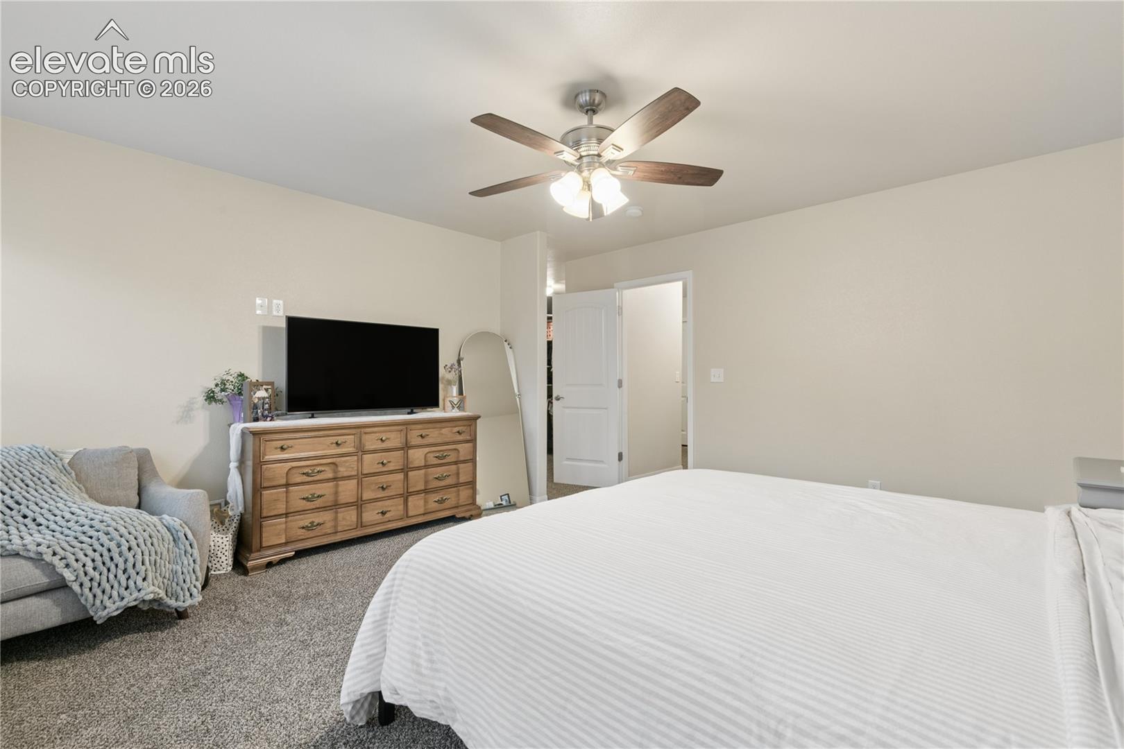 Wall-to-wall carpeting and a ceiling fan with integrated lighting