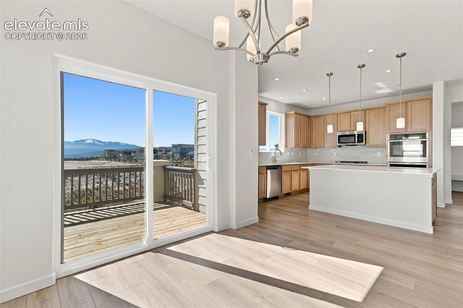 Spacious kitchen featuring light wood cabinetry, stainless steel appliances, and a central island
