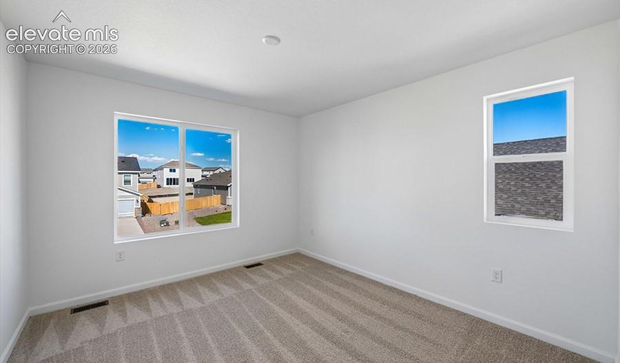 Interior space featuring wall-to-wall carpeting and multiple windows with white trim