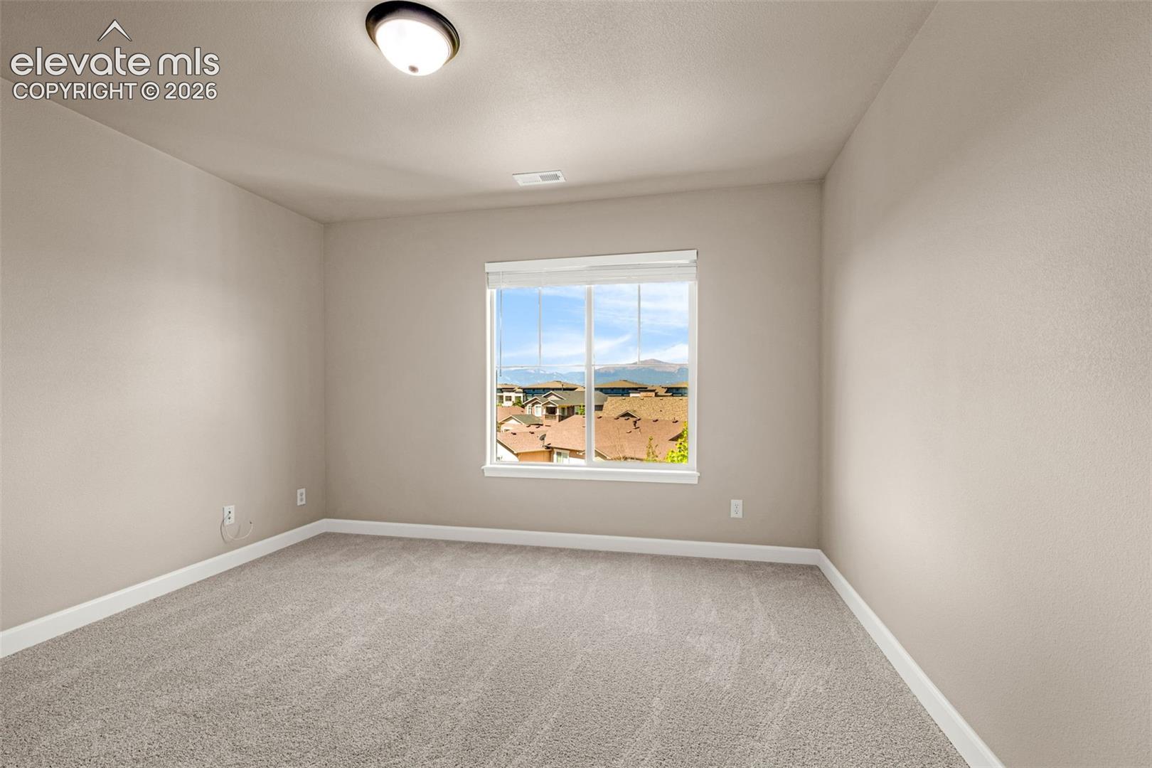 Upper Level Bedroom 3; new carpet, new baseboards, new blinds, new lighting AND with stunning views of Pikes Peak.