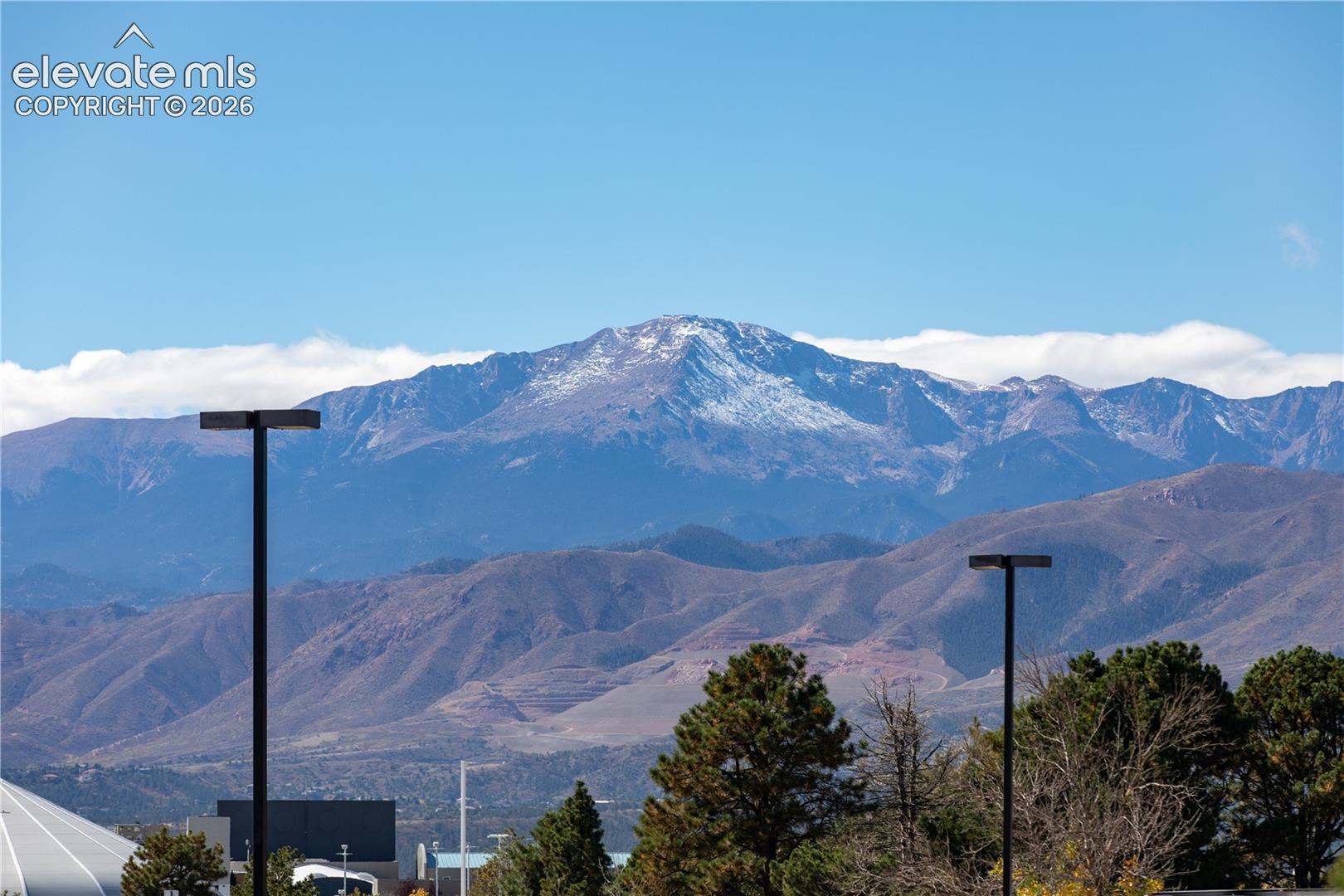 Prominent mountain backdrop featuring snow-capped peaks and mature coniferous trees