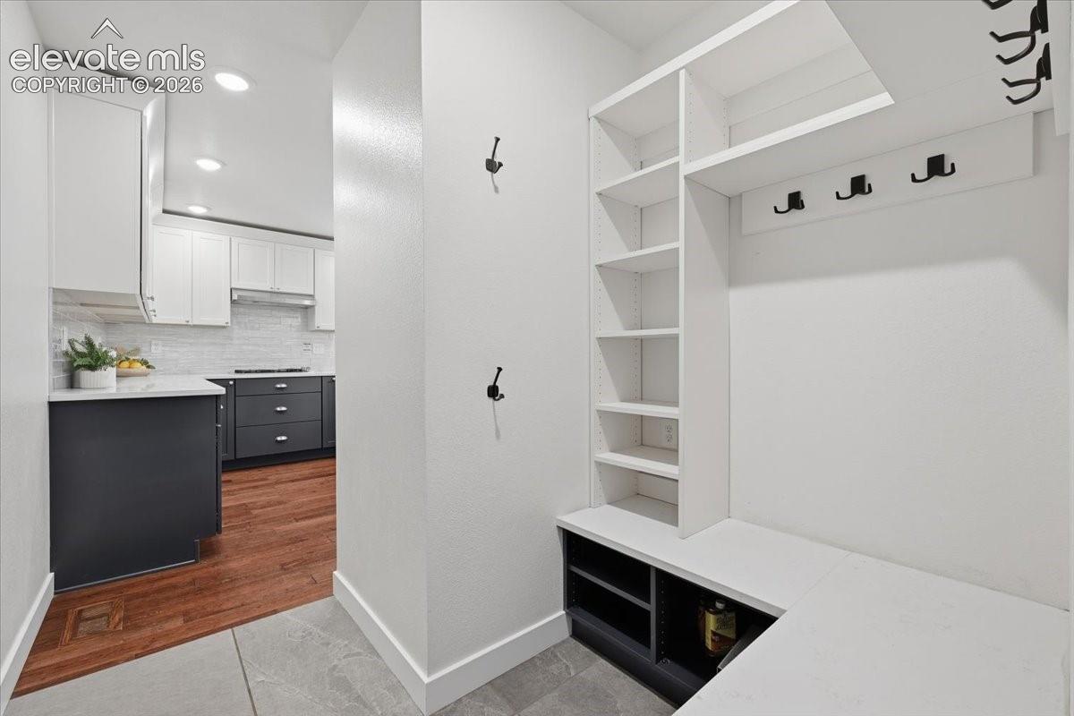 Built-in entryway storage with shelving and bench seating with access from the Garage