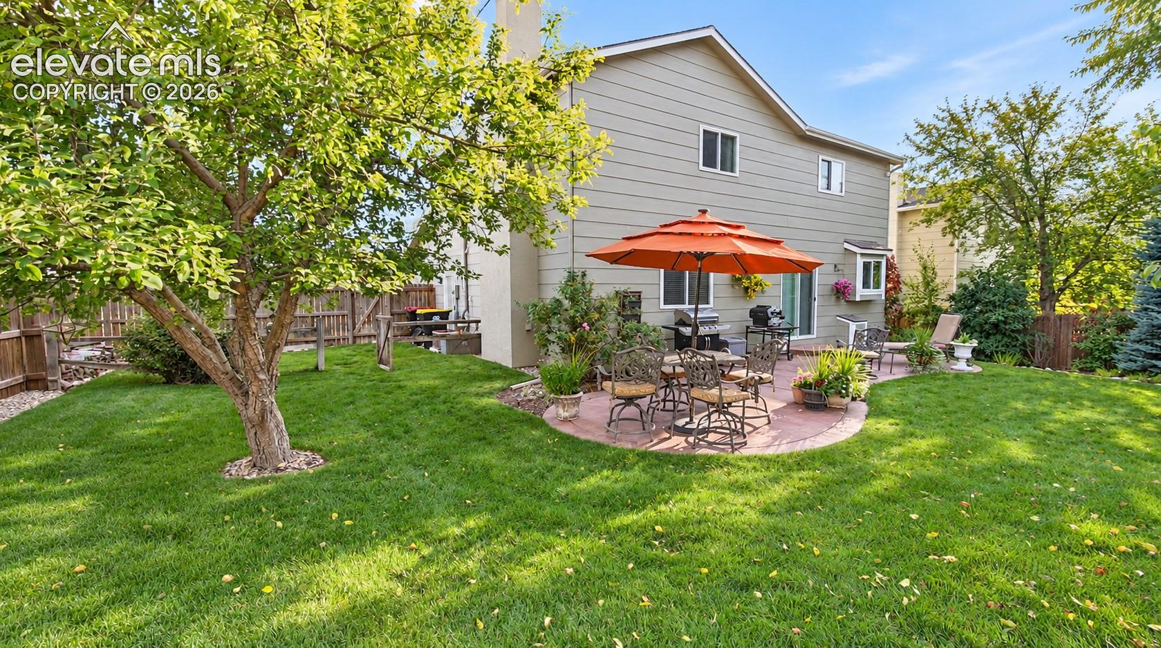 Beautiful park like setting with mature trees and grass, and concrete patio for dining and relaxation.