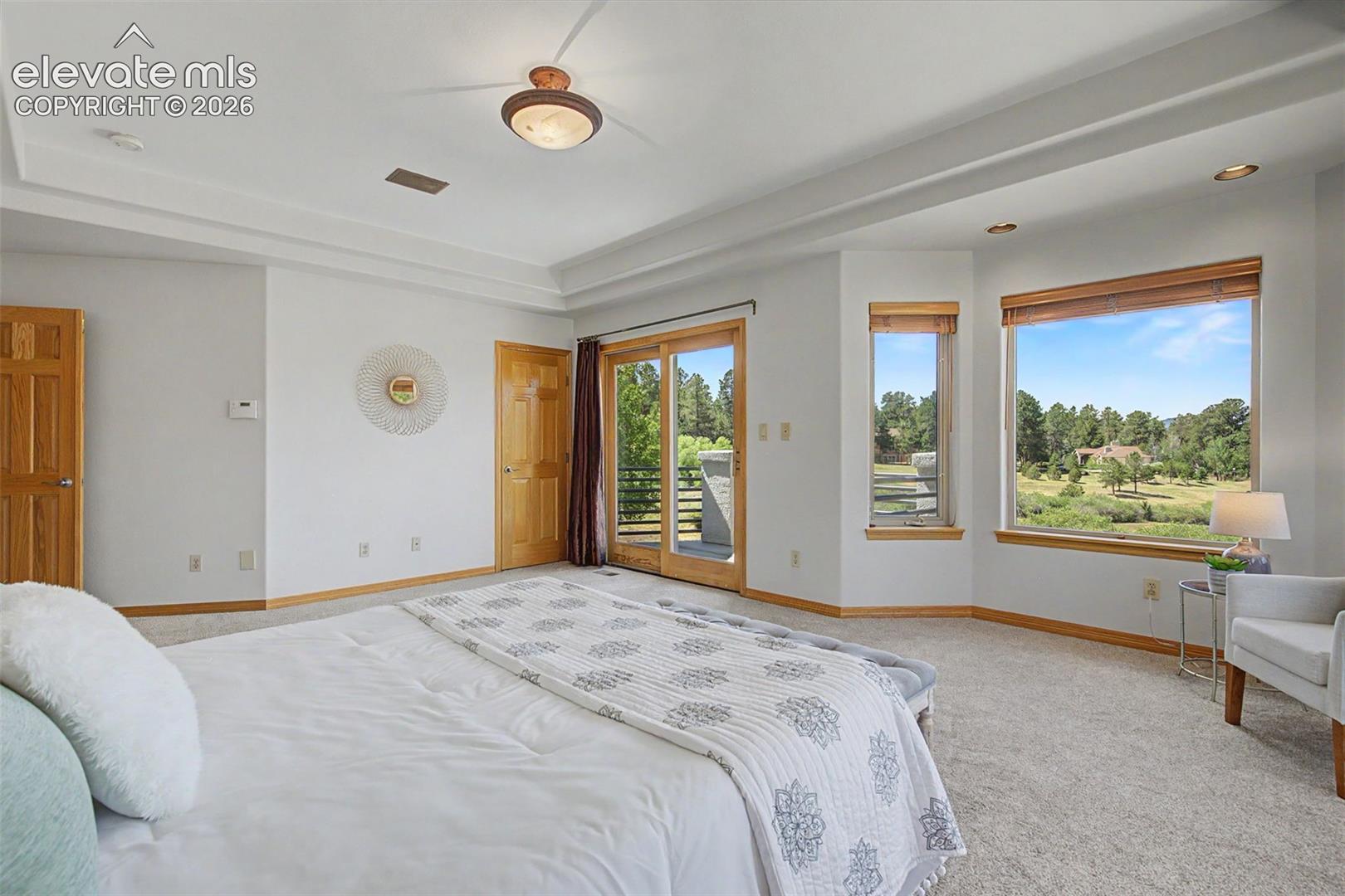 Spacious room with tray ceiling and recessed lighting