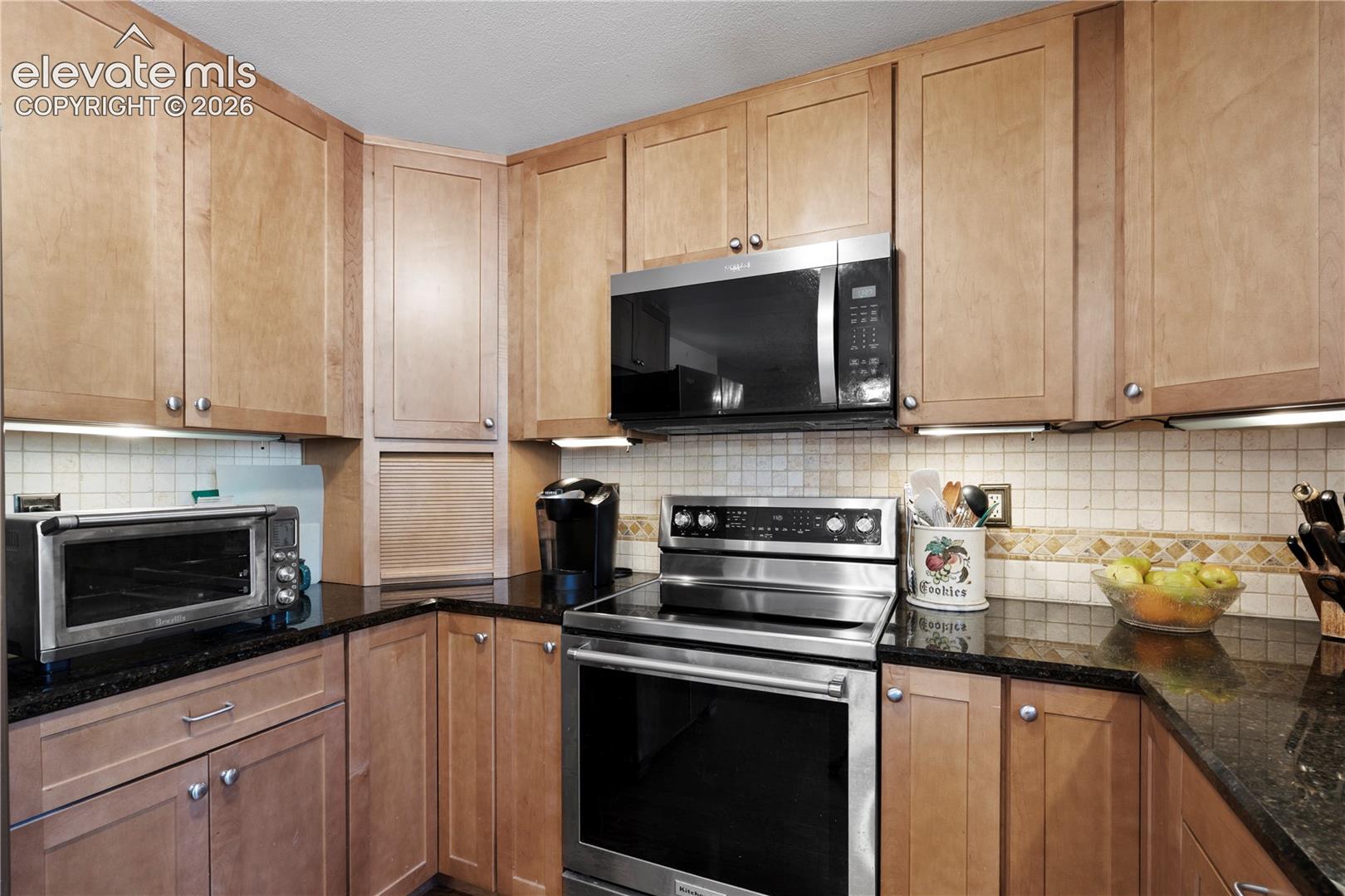 Wood-finish cabinetry paired with dark countertops
