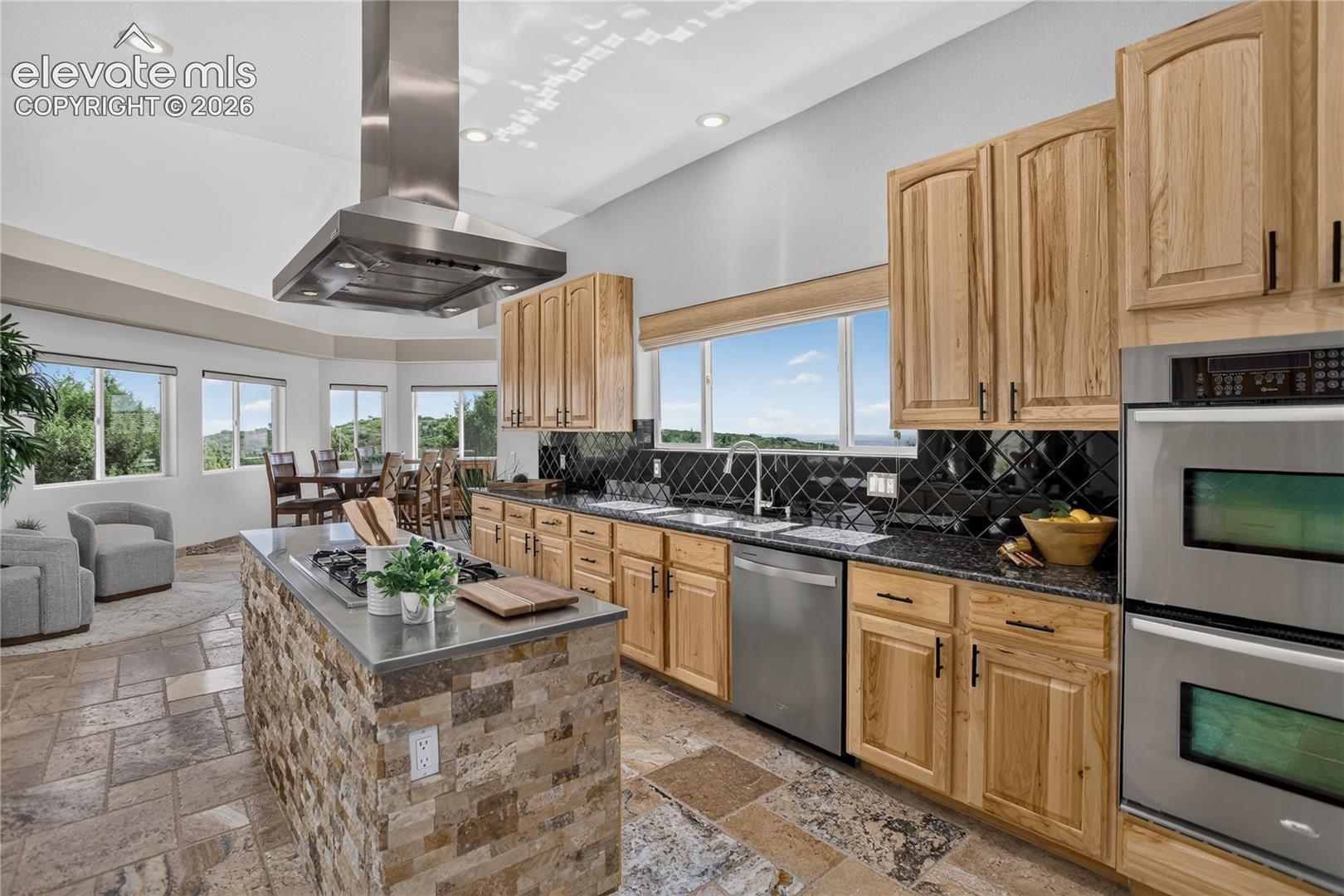 Dual oven & lava onyx travertine flooring that flows into adjacent sunroom