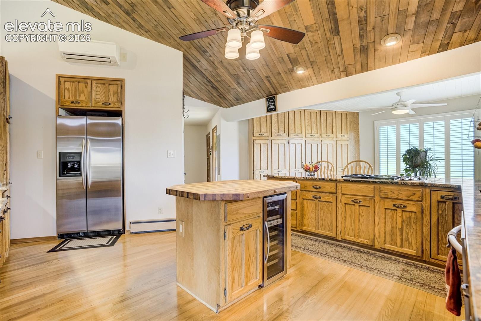 Island, breakfast bar with gas stove top and pantry wall behind.