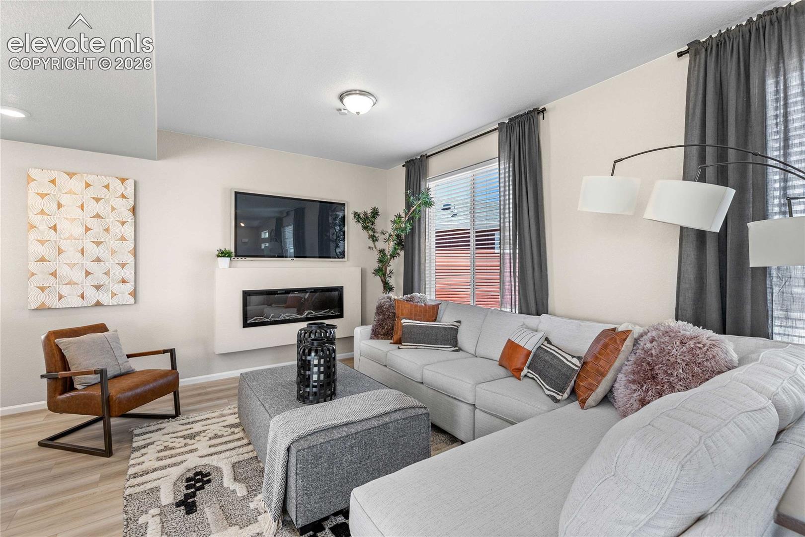 Recessed lighting, wood-finish flooring, and a modern fireplace with a white mantel
*photos of a model home*