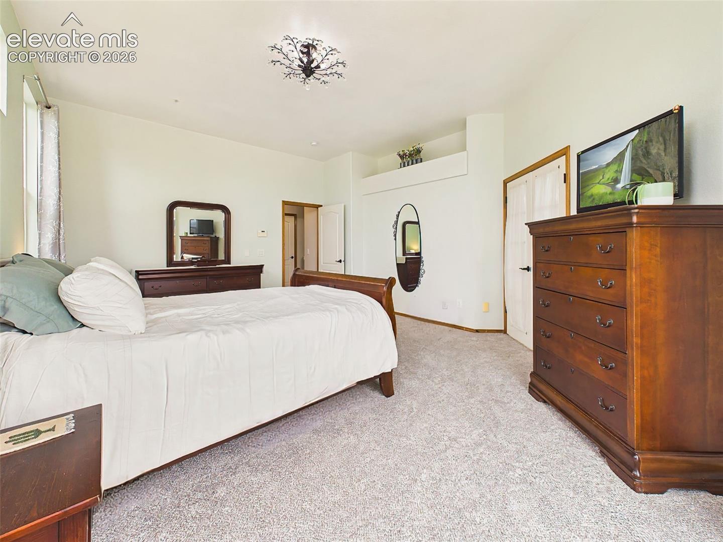 Comfortable primary retreat with generous room dimensions, soft natural light, and a calming neutral color palette.