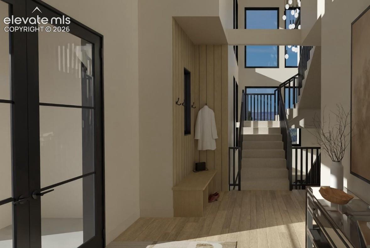 Two story entry with custom iron double doors, iron railings, and white oak flooring