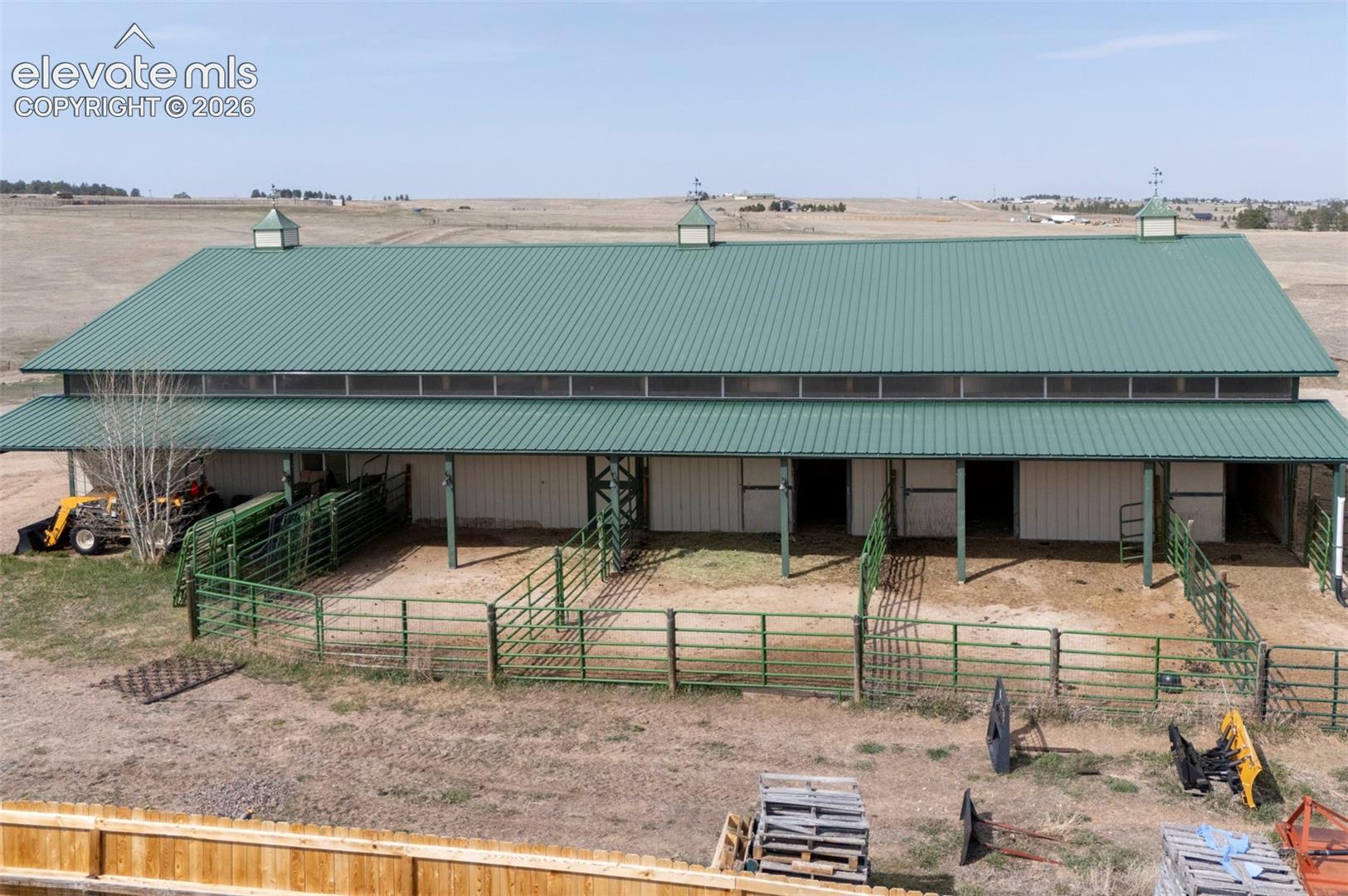 50x100 metal drive-through barn has a concrete floor, w/ a half bath, 4 stalls w/turnouts (3 w/ automatic waterers), 2hydrants, a horse wash bay, work benches, and a heated tack room