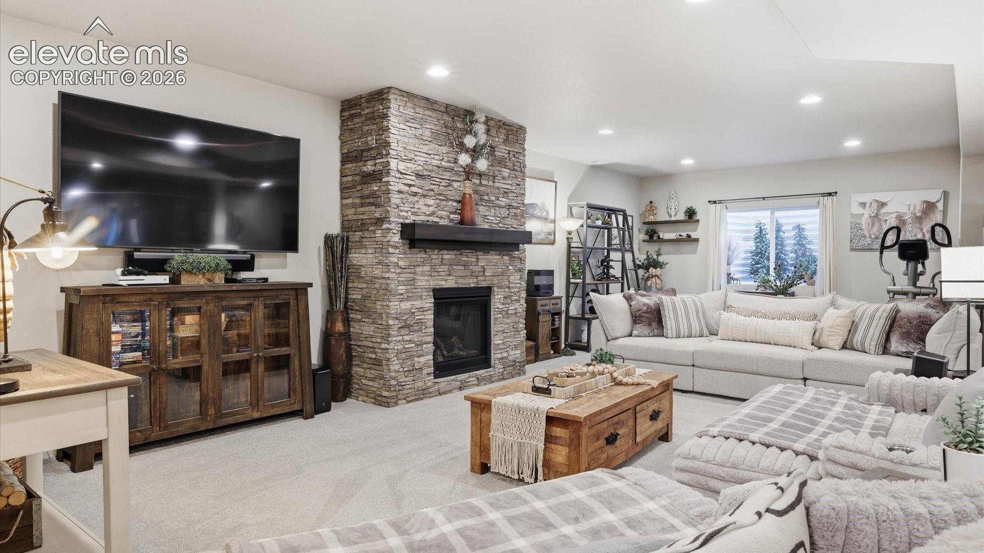 FIRESIDE LUXURY, ON EVERY LEVEL — This expansive family room features a stunning fireplace designed to mirror the one above, carrying the home’s sophisticated style into the lower level.