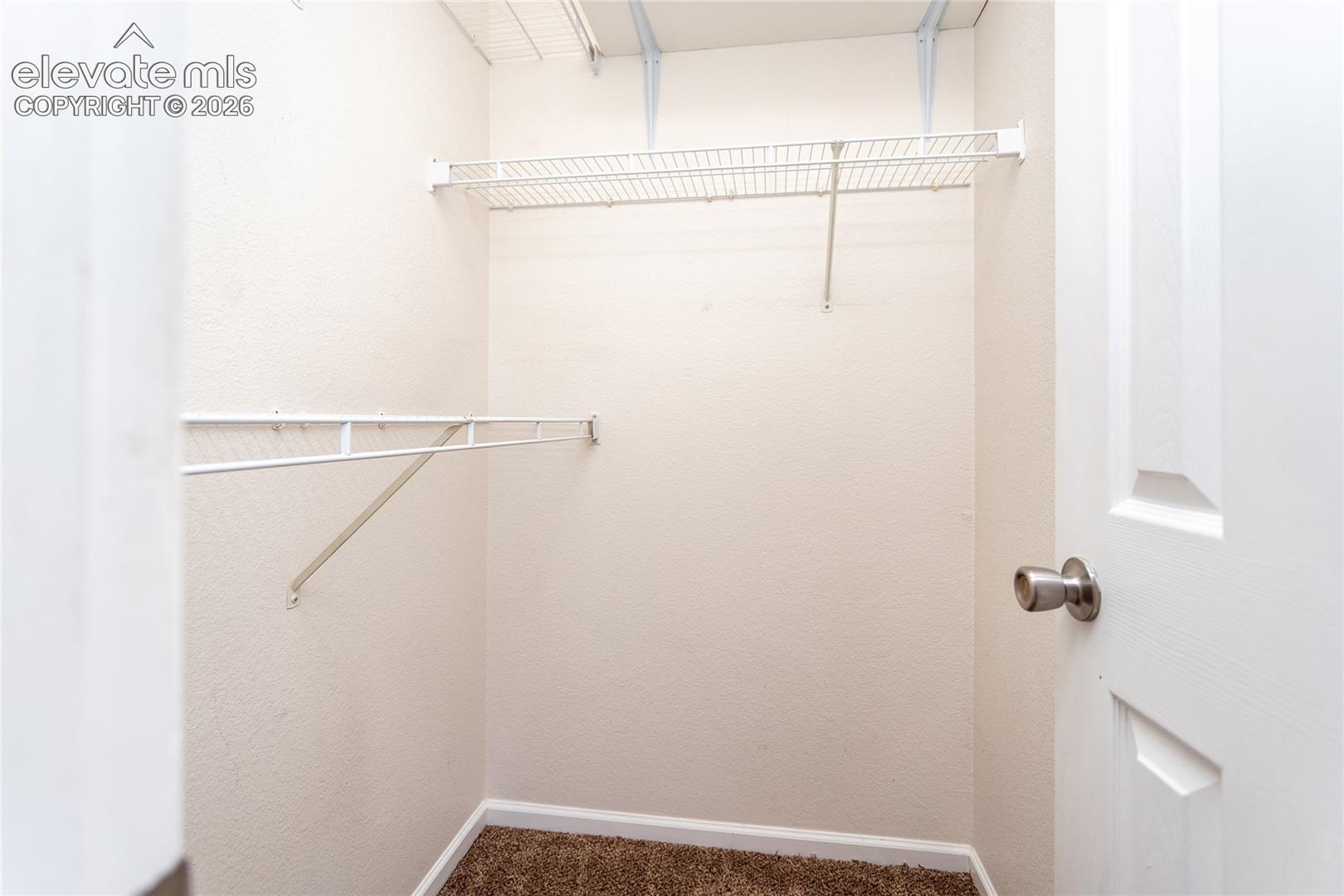 The walk-in primary closet comes fully equipped with organized wire shelving