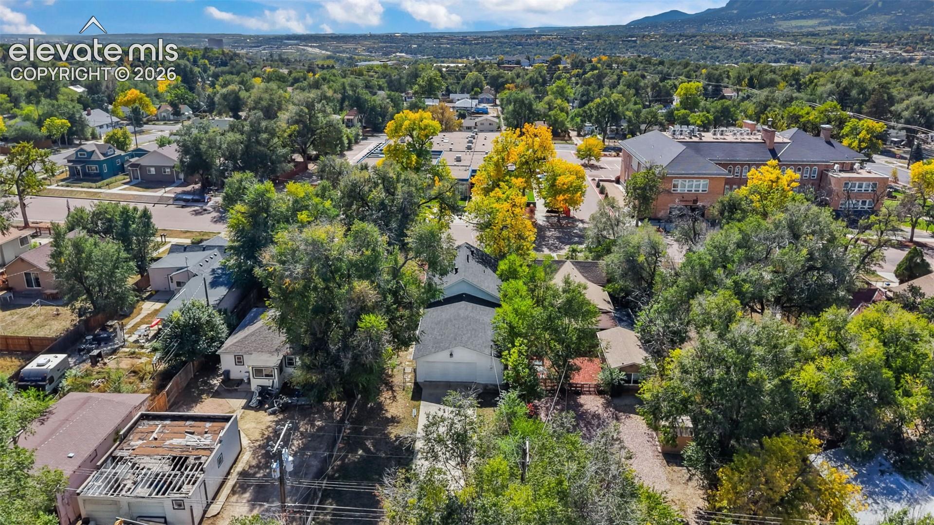 Aerial view showcasing a mature tree-lined property nestled in a verdant neighborhood setting