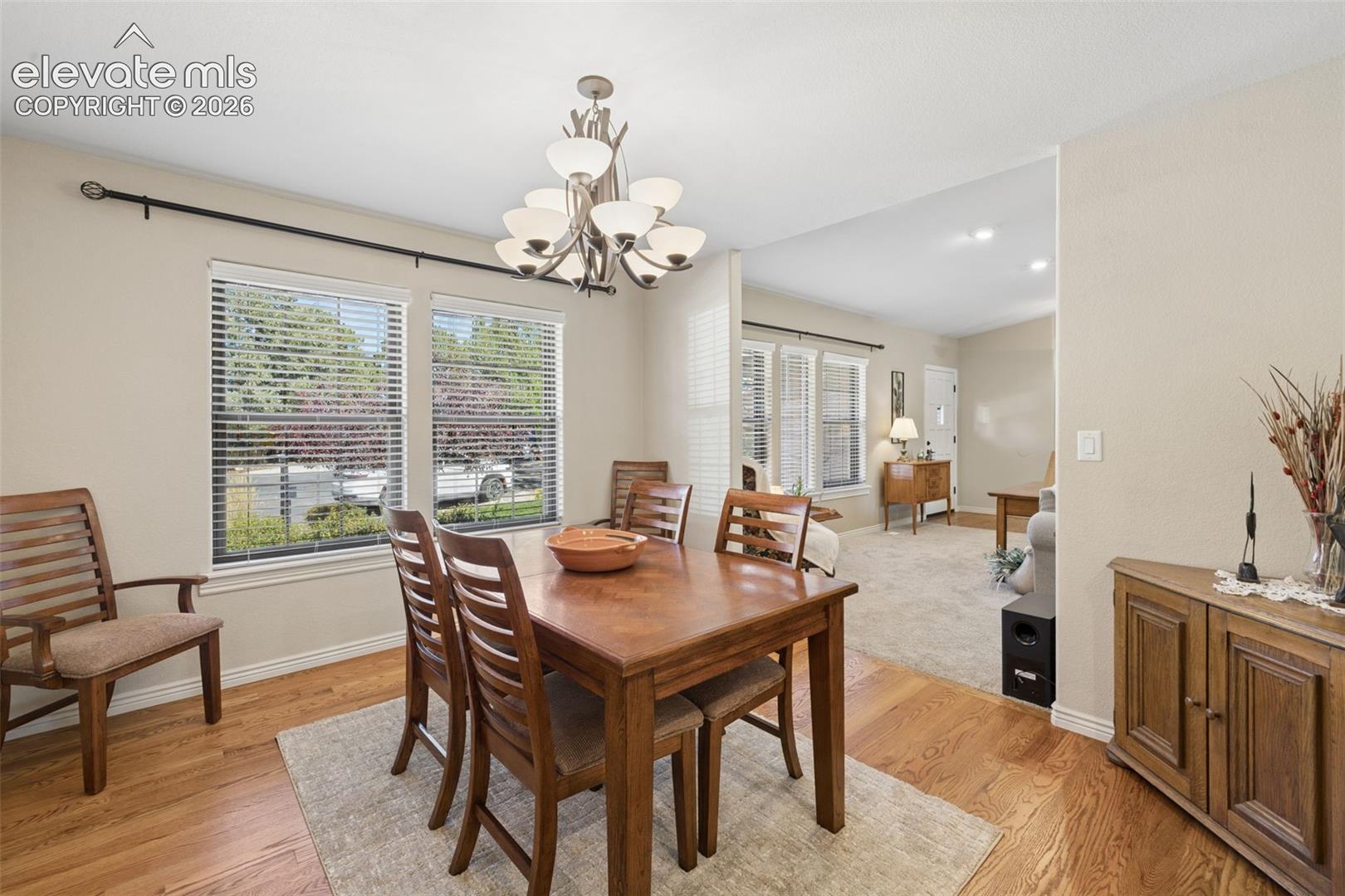 Separate dining area with wood floors and large windows