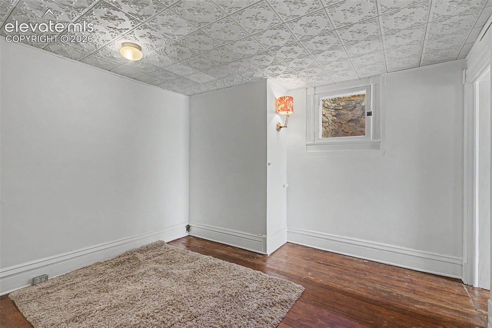 Secondary suite bedroom featuring hardwood flooring