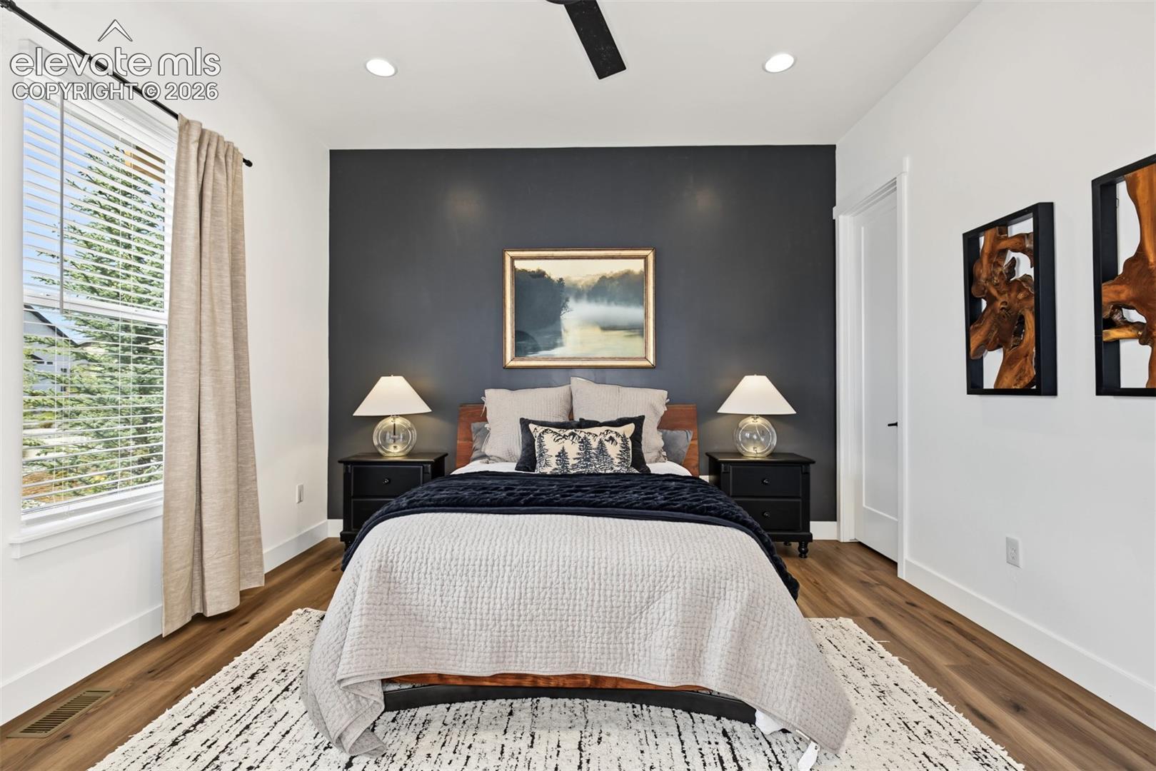 Spacious secondary bedroom featuring abundant natural light, large windows, and a modern ceiling fan, creating a bright and inviting retreat.