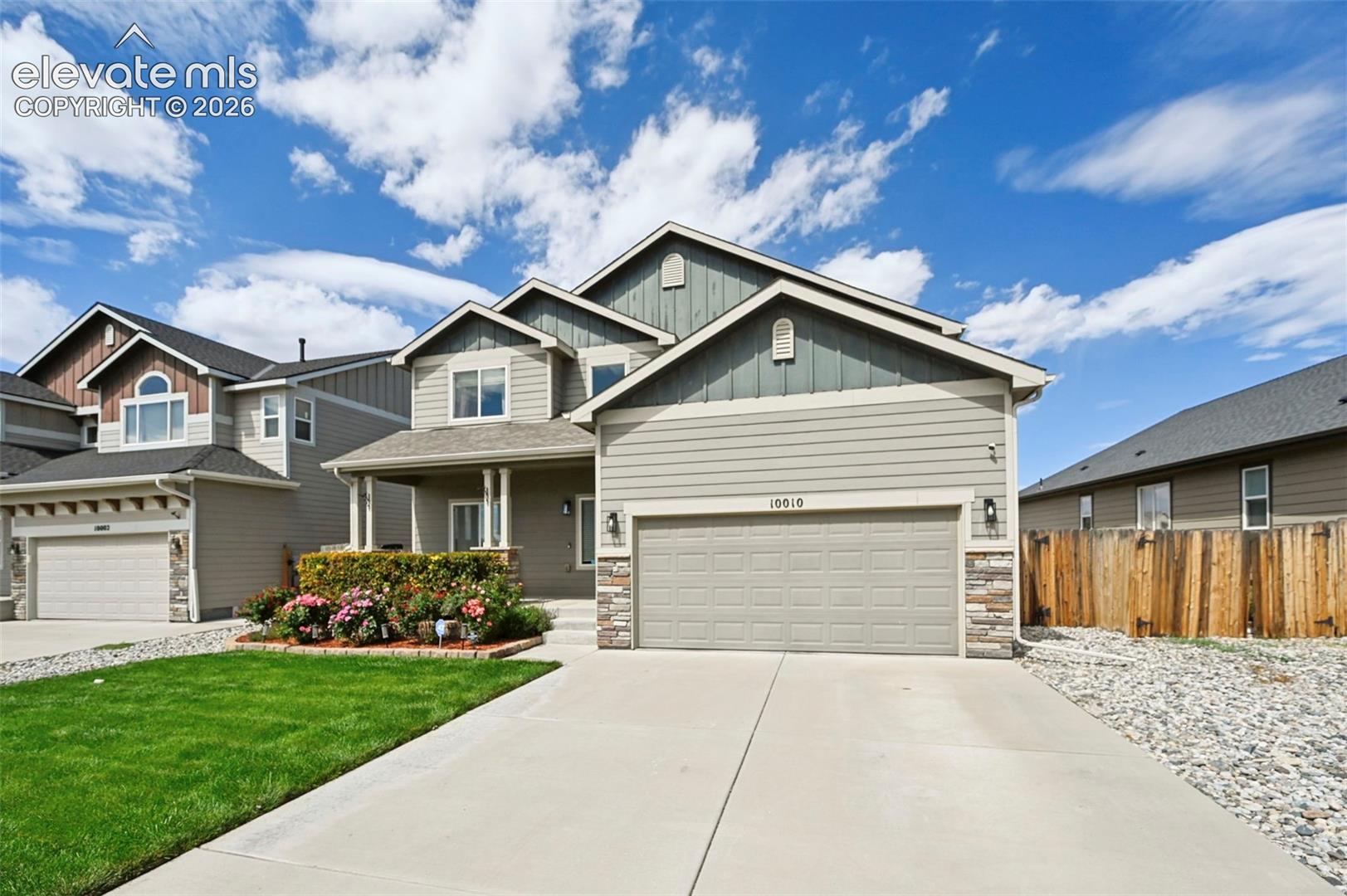 Two-story residence featuring a covered entry porch, an attached two-car garage, and a concrete driveway