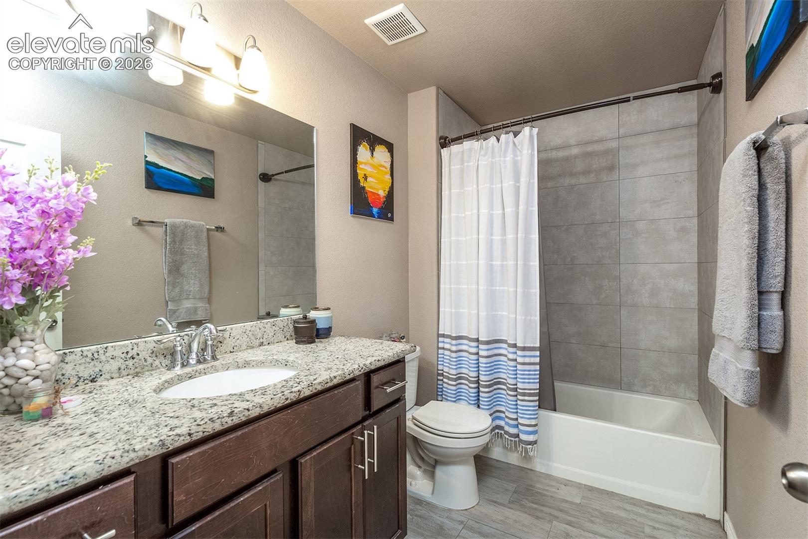 Full bathroom featuring an oversized vanity and shower/tub combination