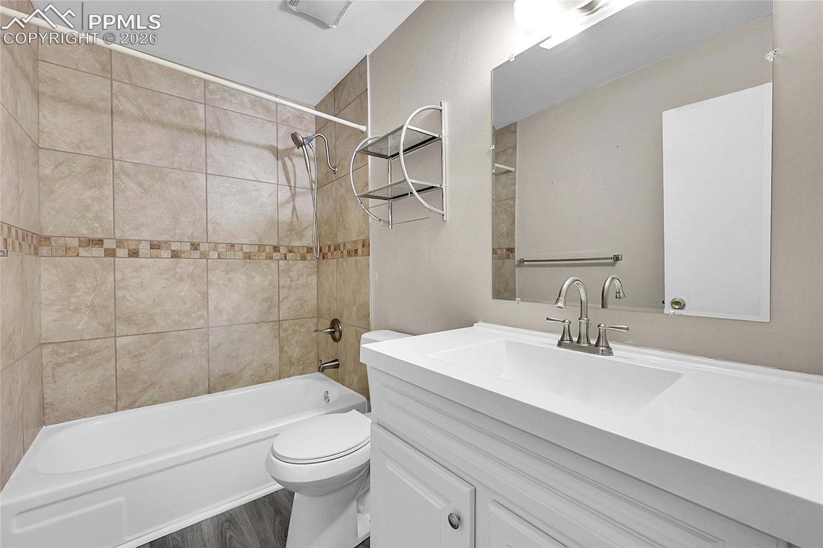 Bathroom with vanity, tub / shower combination, and wood finished floors
