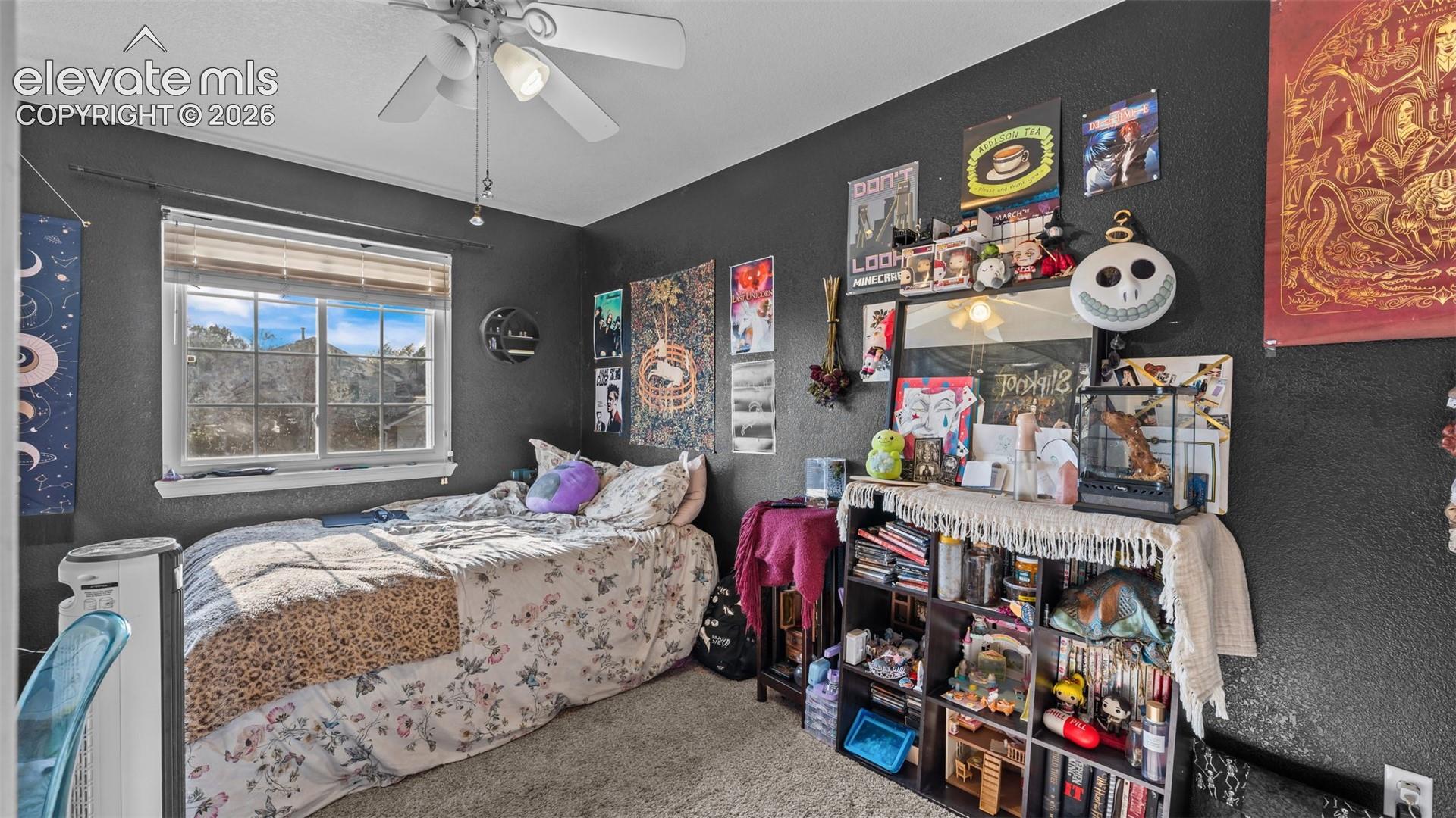 Textured wall finish, ceiling fan with integrated lighting, window with blinds, and built-in shelving