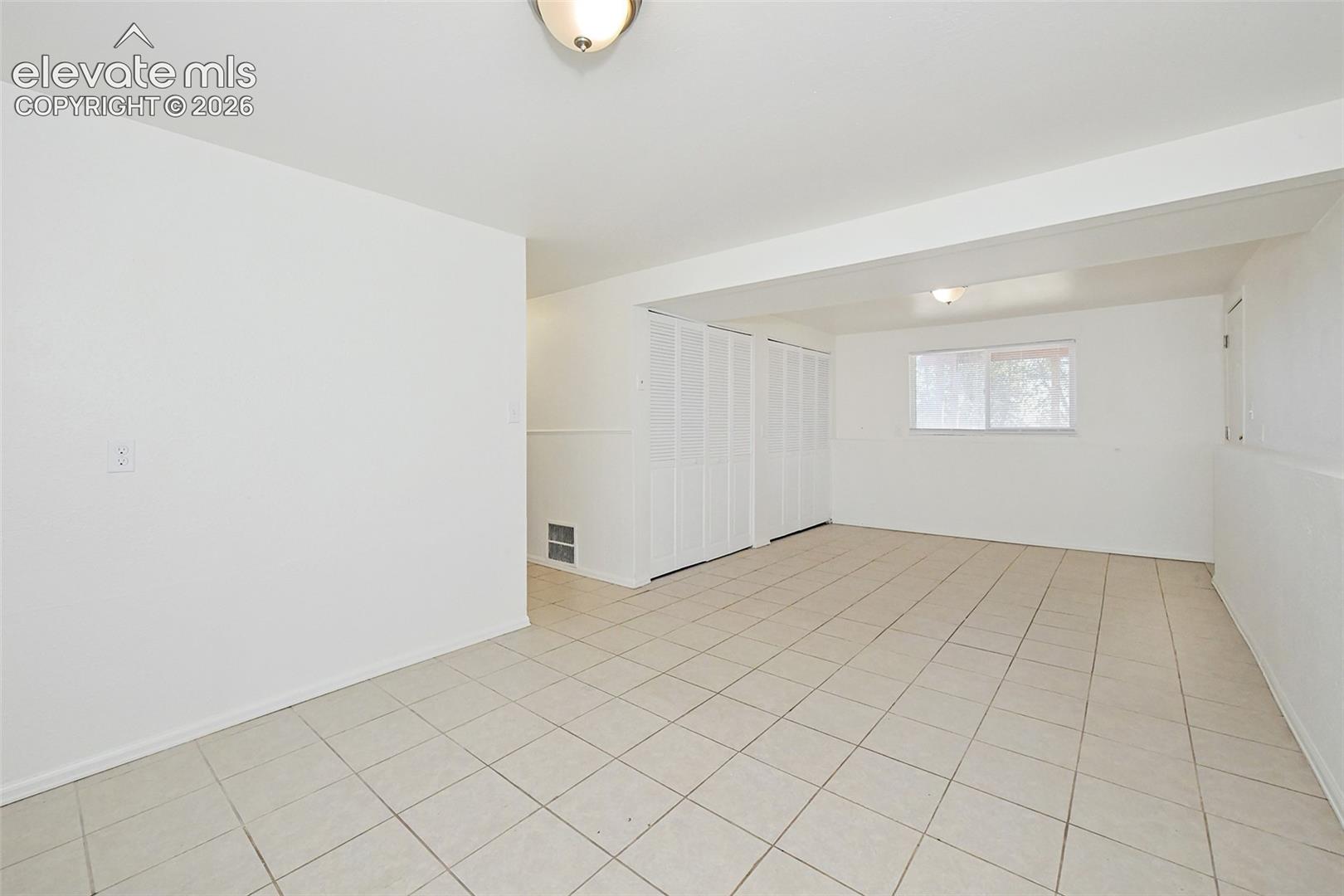 Neutral-toned ceramic tile flooring, new bi-fold closet doors, and new ceiling-mounted light fixtures