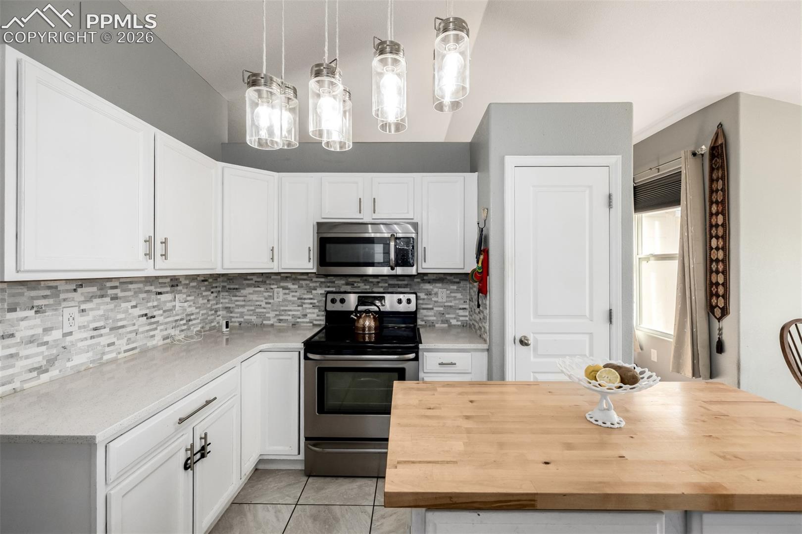 Updated Kitchen with beautiful white cabinetry and quartz/butcher block countertops