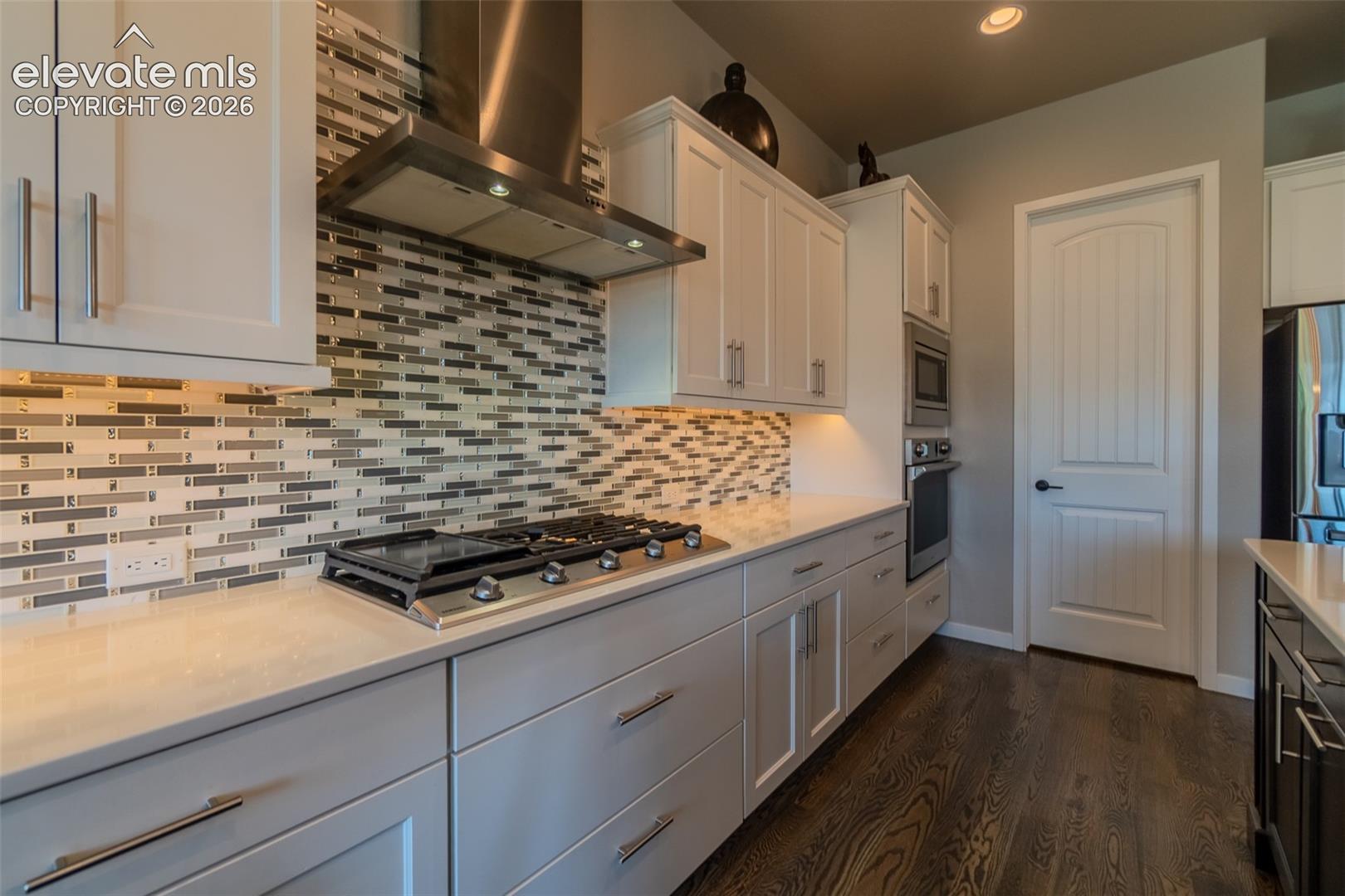 Modern kitchen featuring wood-finish flooring and light-toned cabinetry