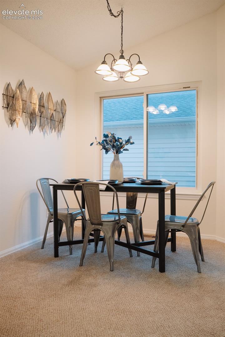 Five-light chandelier with frosted glass shades, neutral carpeting, and a sliding window