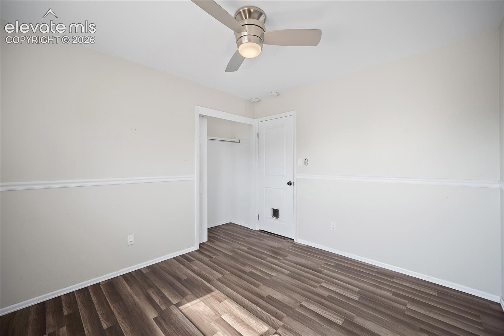Bedroom with ceiling fan and updated flooring.