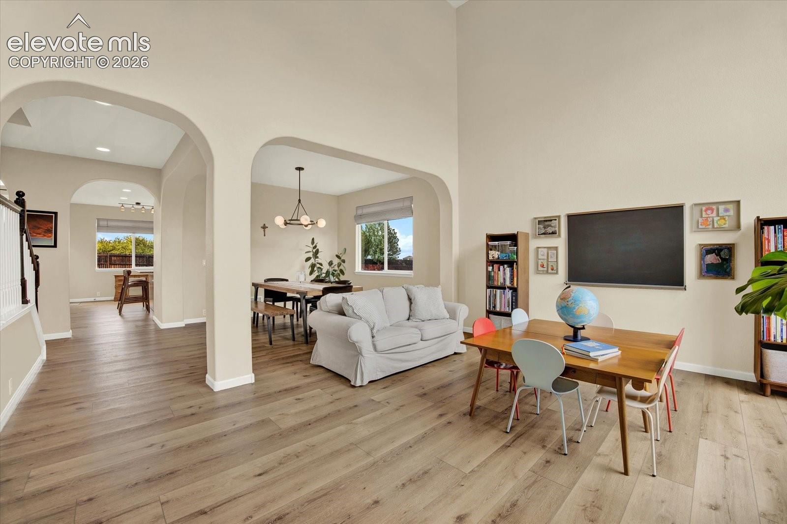 High-ceiling interior space featuring wood-finish flooring and multiple arched architectural openings