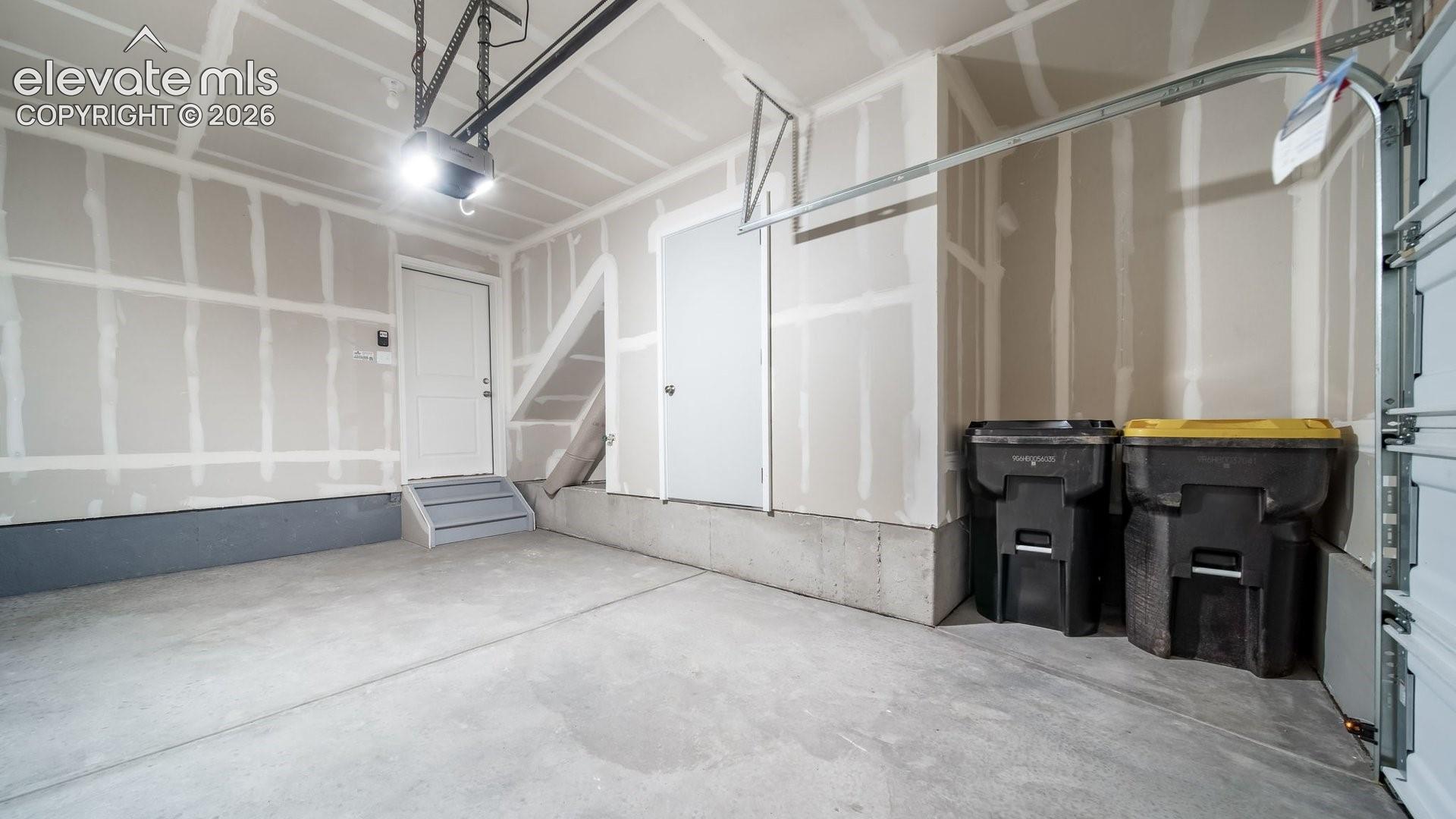 Concrete flooring, interior access door, automatic garage door opener, overhead lighting, partially finished walls
*photos of a model home*