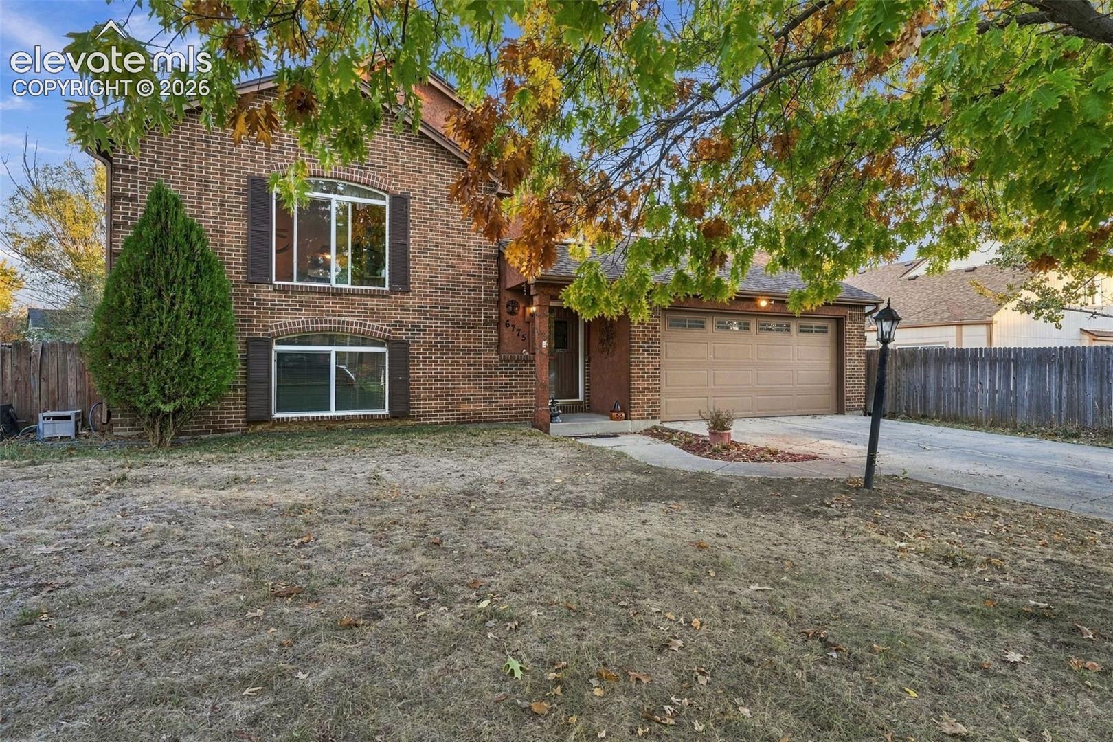 Brick exterior featuring arched window headers, a covered entryway, and a two-car attached garage