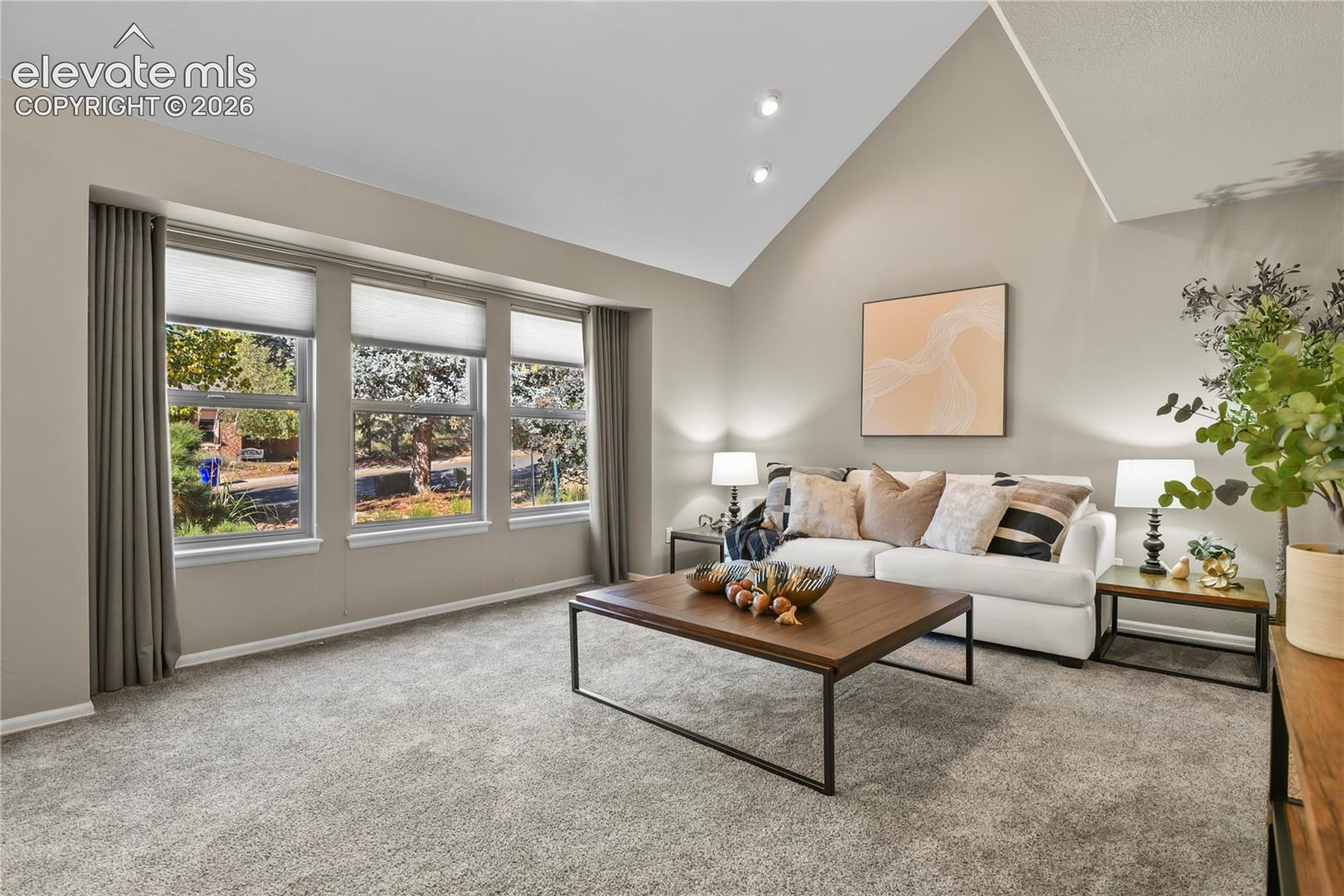 Vaulted ceiling, wall-to-wall carpeting, and a triple-window configuration with top-down, bottom-up shades and recessed lighting