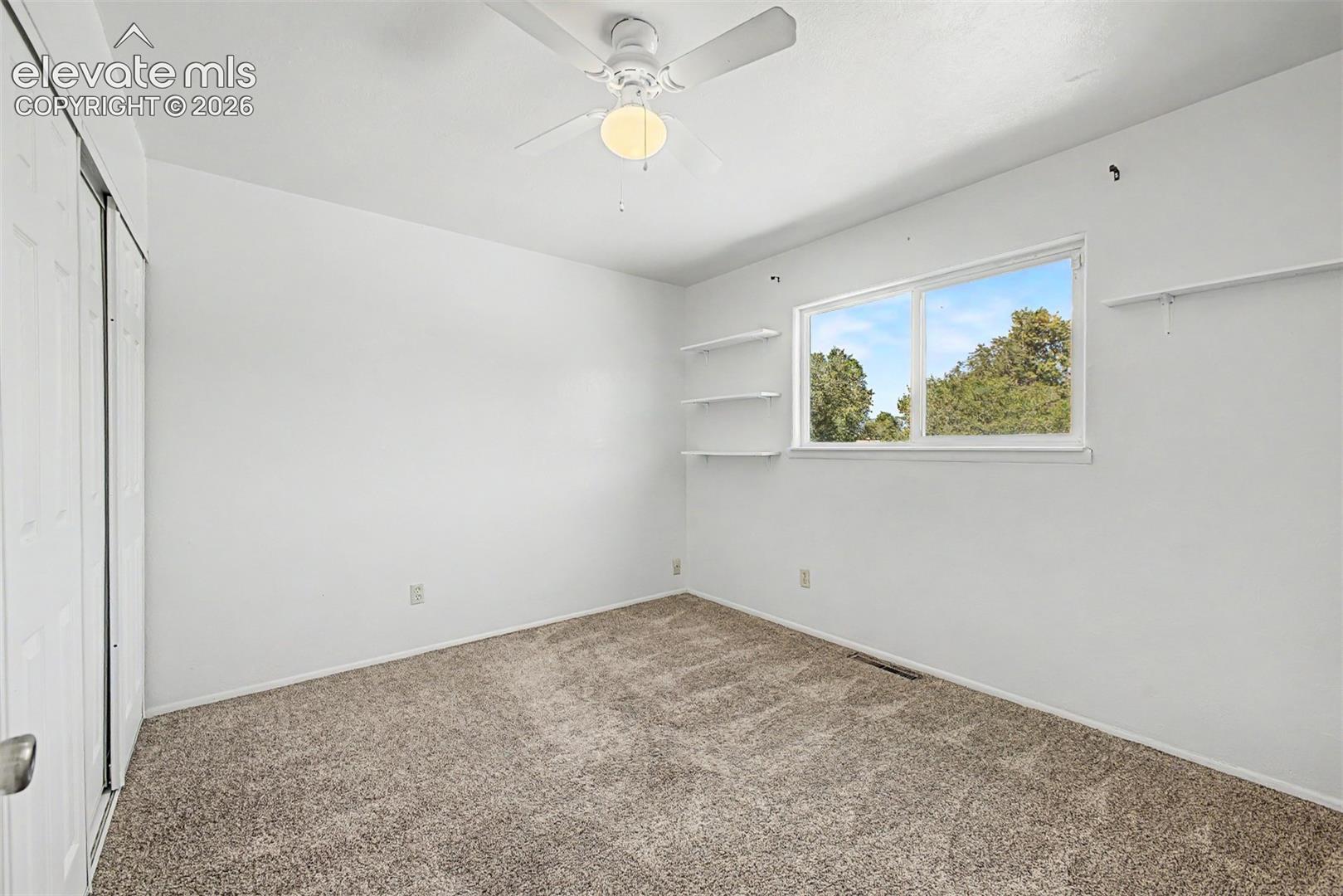 Guest bedroom offers neutral carpet, natural lighting and a mountain view