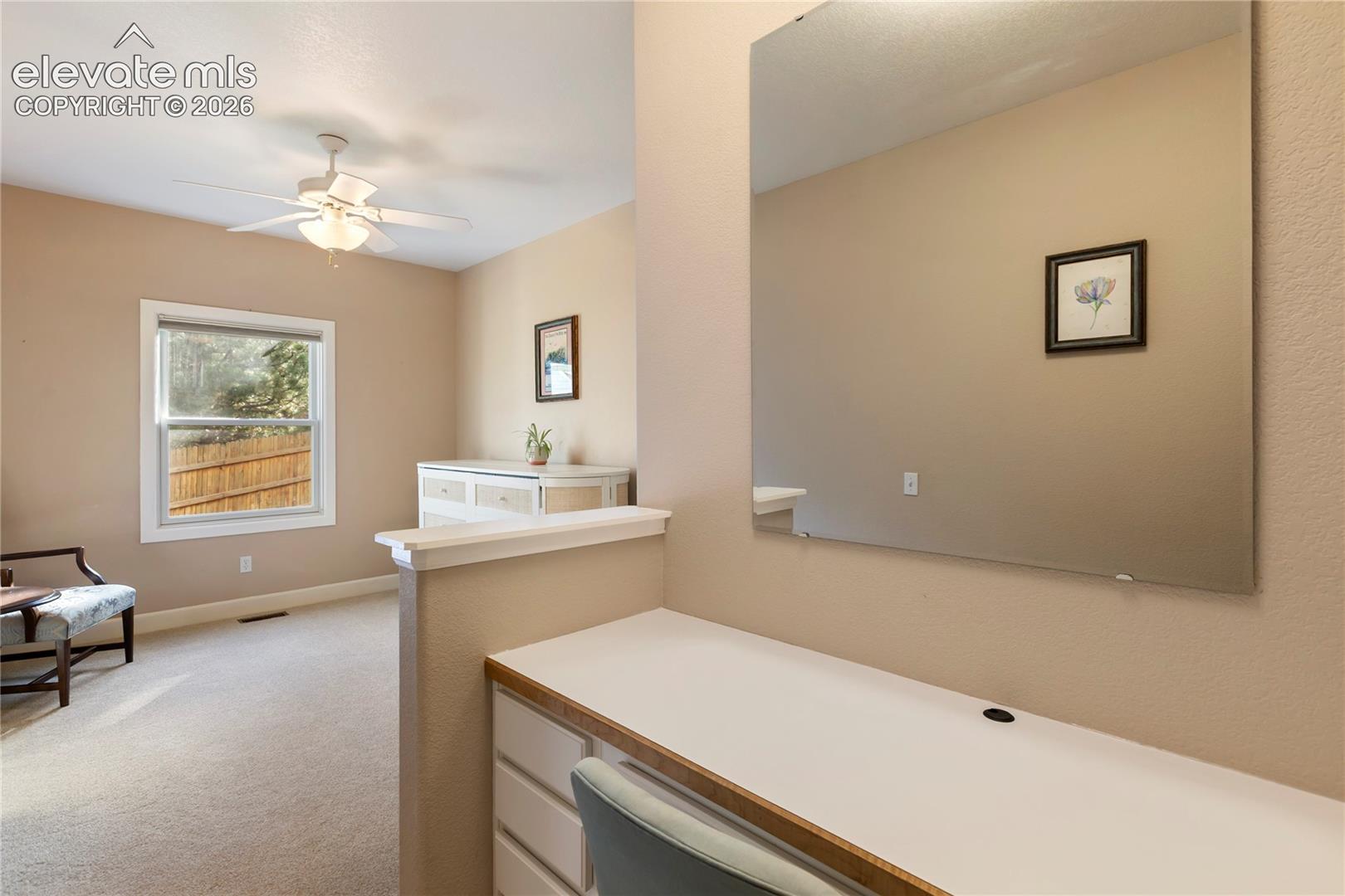Built-in desk with integrated storage and a large wall-mounted mirror