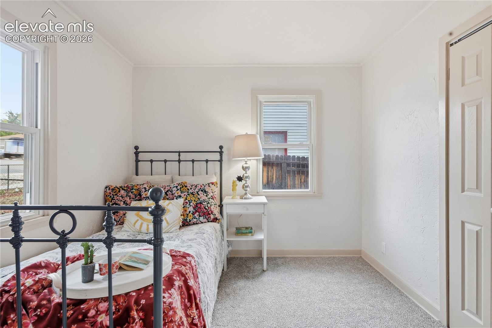 Neutral-toned wall-to-wall carpeting, dual windows, and a bi-fold closet door