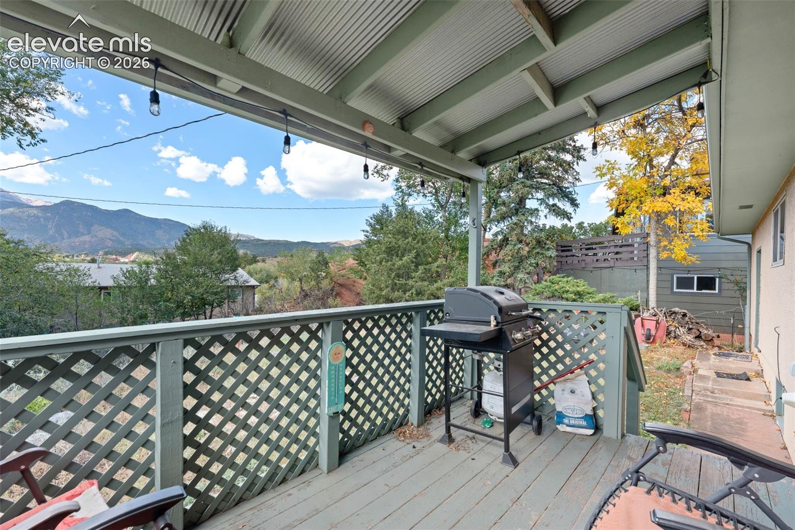 Covered outdoor deck with painted wood flooring and lattice railing