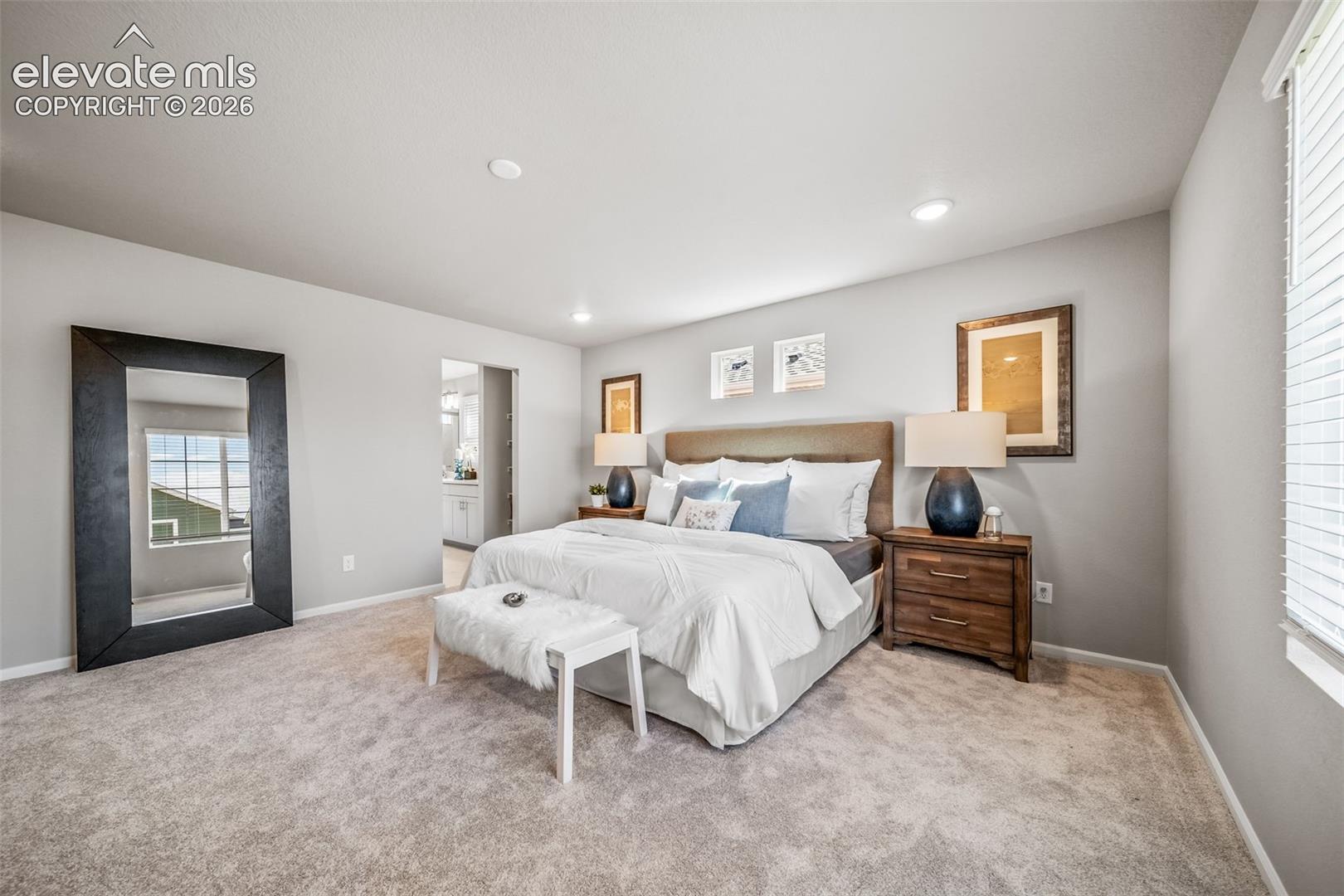 Plush carpeting, recessed lighting, and a window with blinds provide illumination
*photos of a model home*