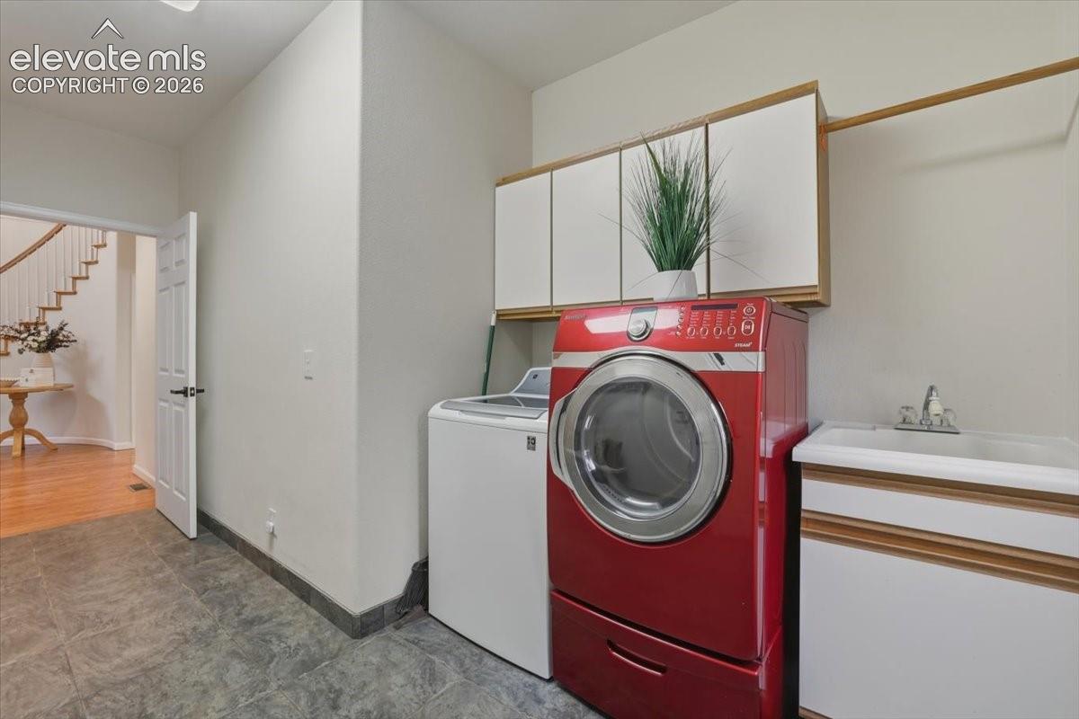 Durable tile flooring, built-in upper cabinetry, utility sink, and ample counter space
