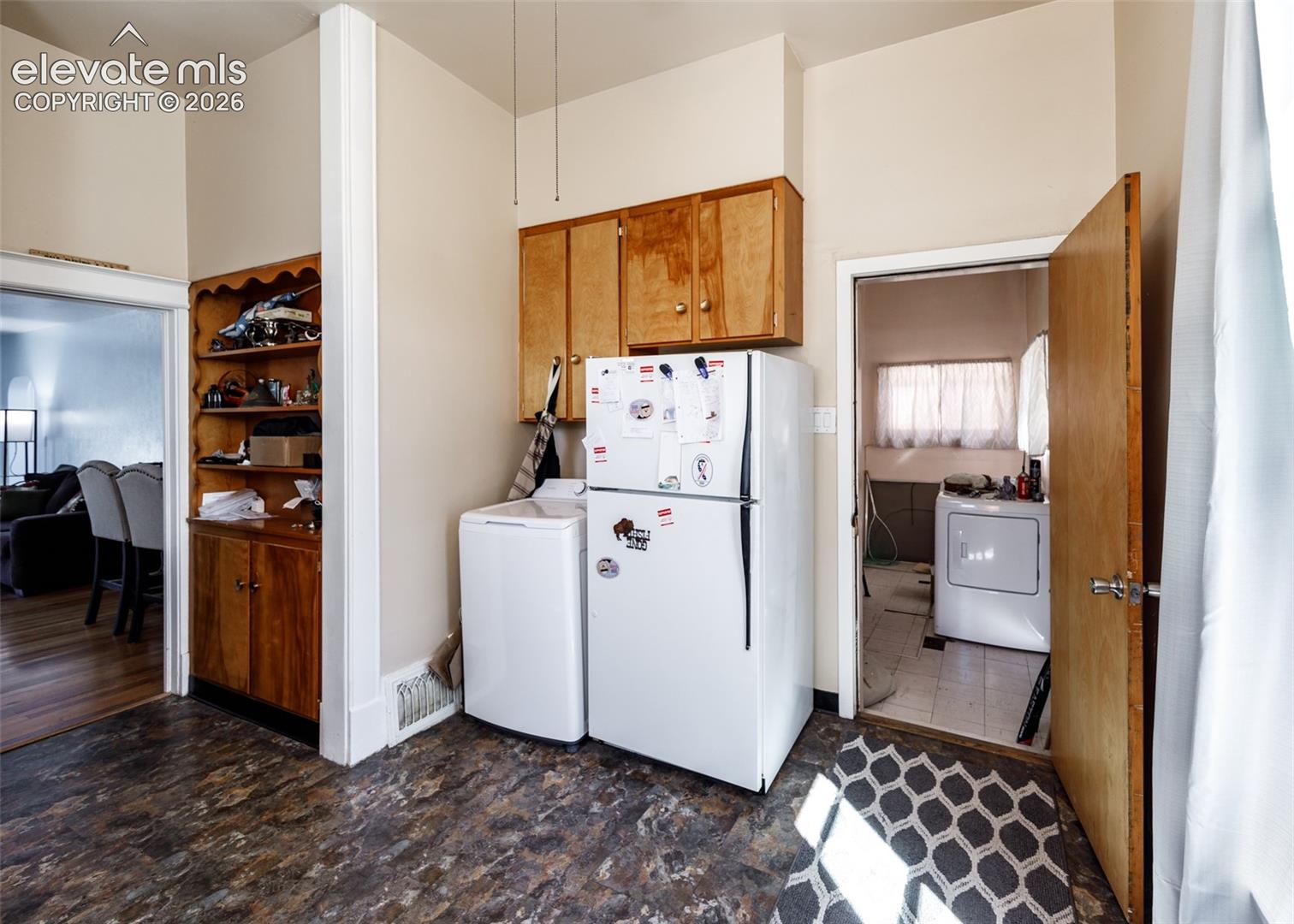 Built-in wood cabinetry, wood-finish flooring, and white appliances