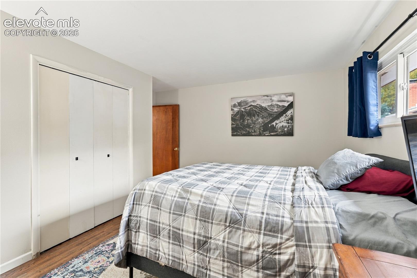 Neutral wall tones, wood-finish flooring, and white bi-fold closet doors