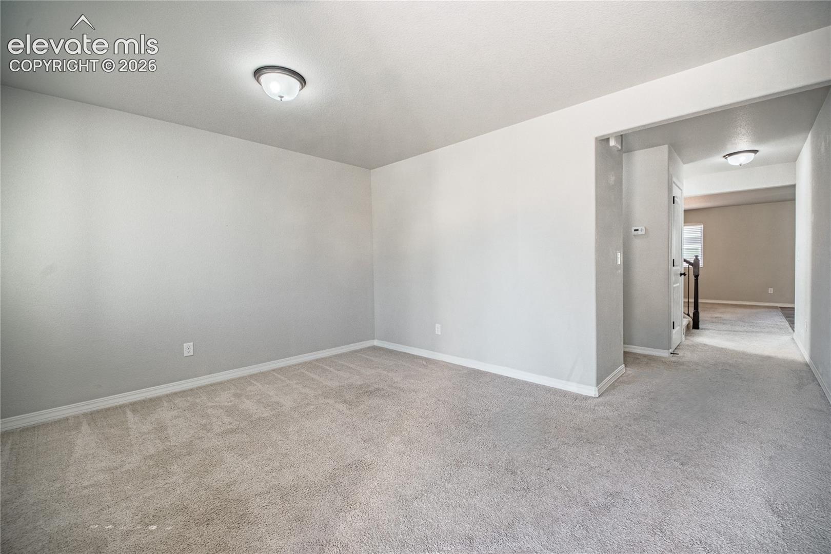 Wall-to-wall carpeting and neutral wall tones create a versatile interior