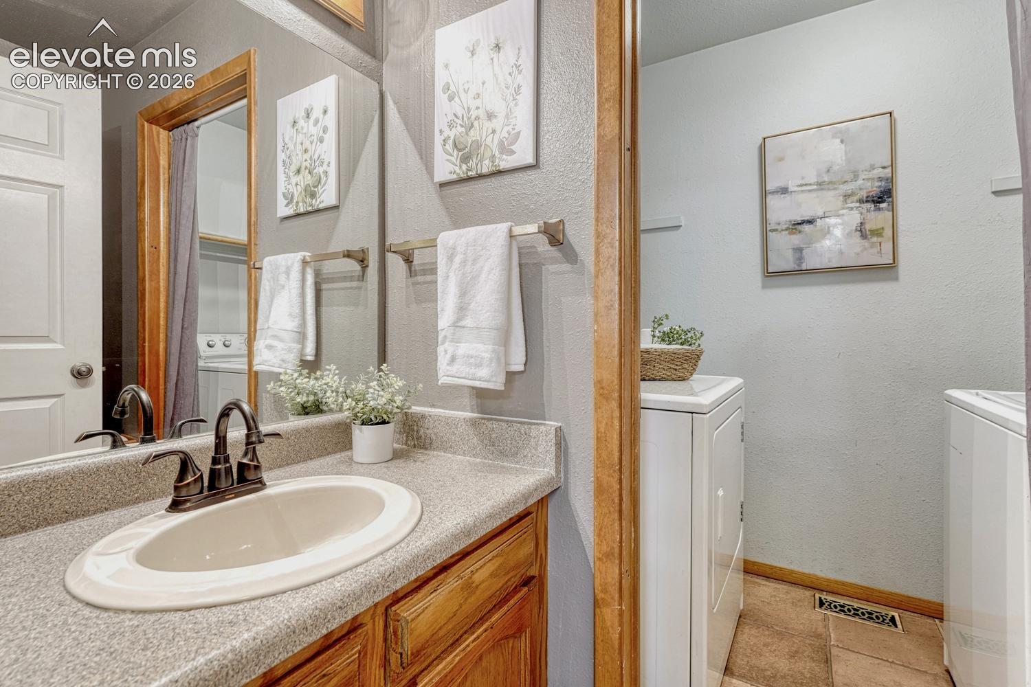 The powder bathroom has a vanity and mirror and entrance into the laundry room with washer and dryer that stay.